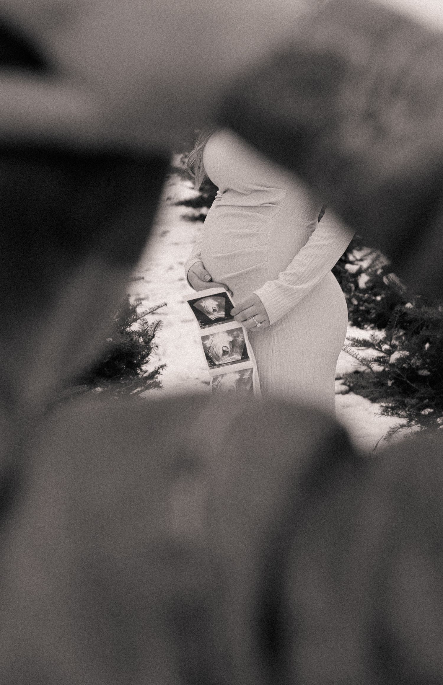 Black and white artistic photograph of scattered photographs on a white surface.