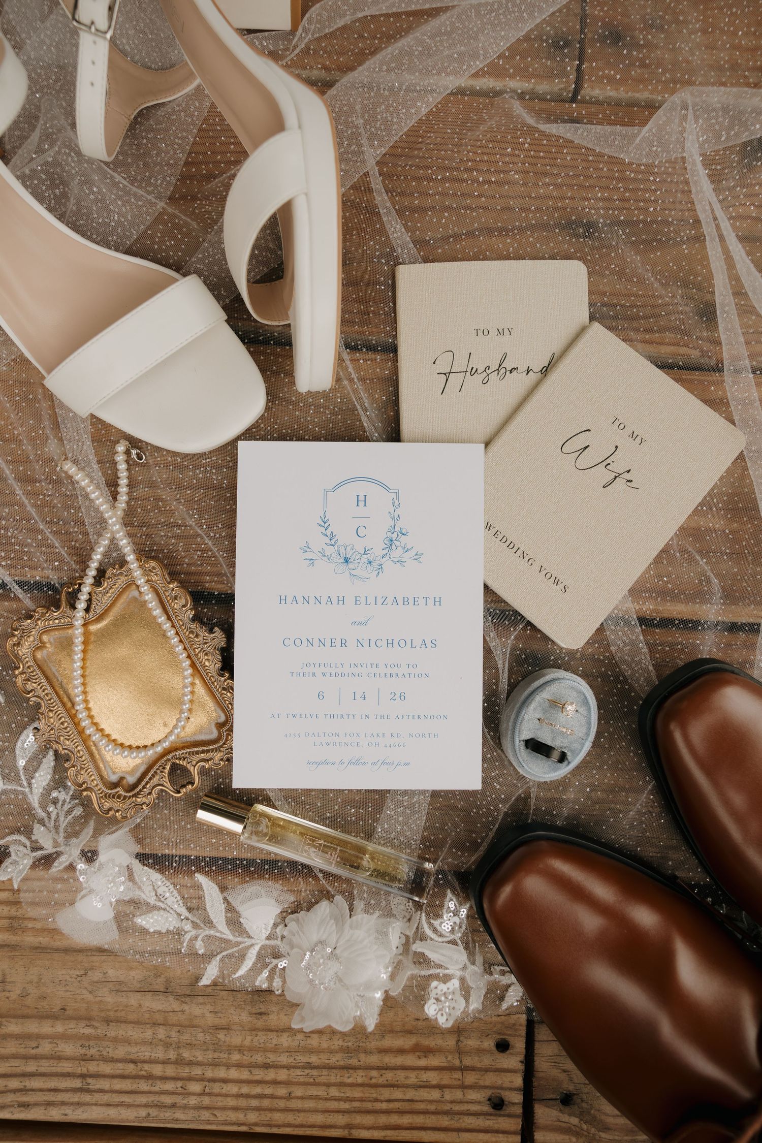 Wedding flat lay with invitation for Hannah Elizabeth and Conner Nicholas, bridal heels, groom shoes, vows books, and accessories.