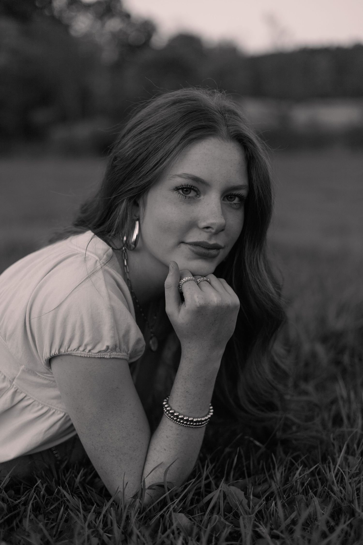 A classic black and white portrait shot in a natural outdoor setting.