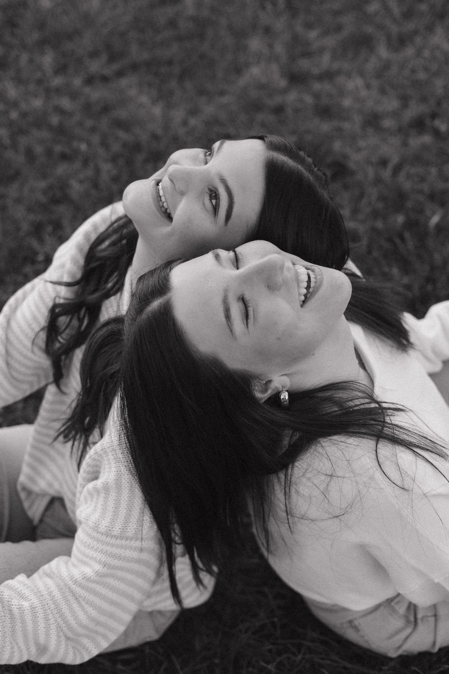 A series of black and white portraits showing someone lying in grass with carefree expressions.