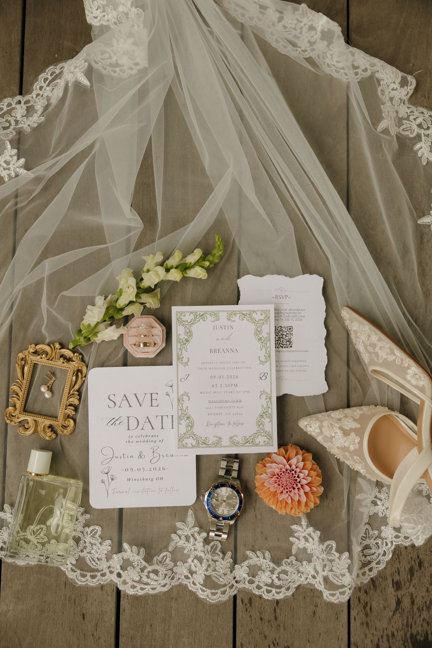 Elegant wedding flat lay with lace veil, floral invitations, save the date, heels, perfume, and jewelry on wood.