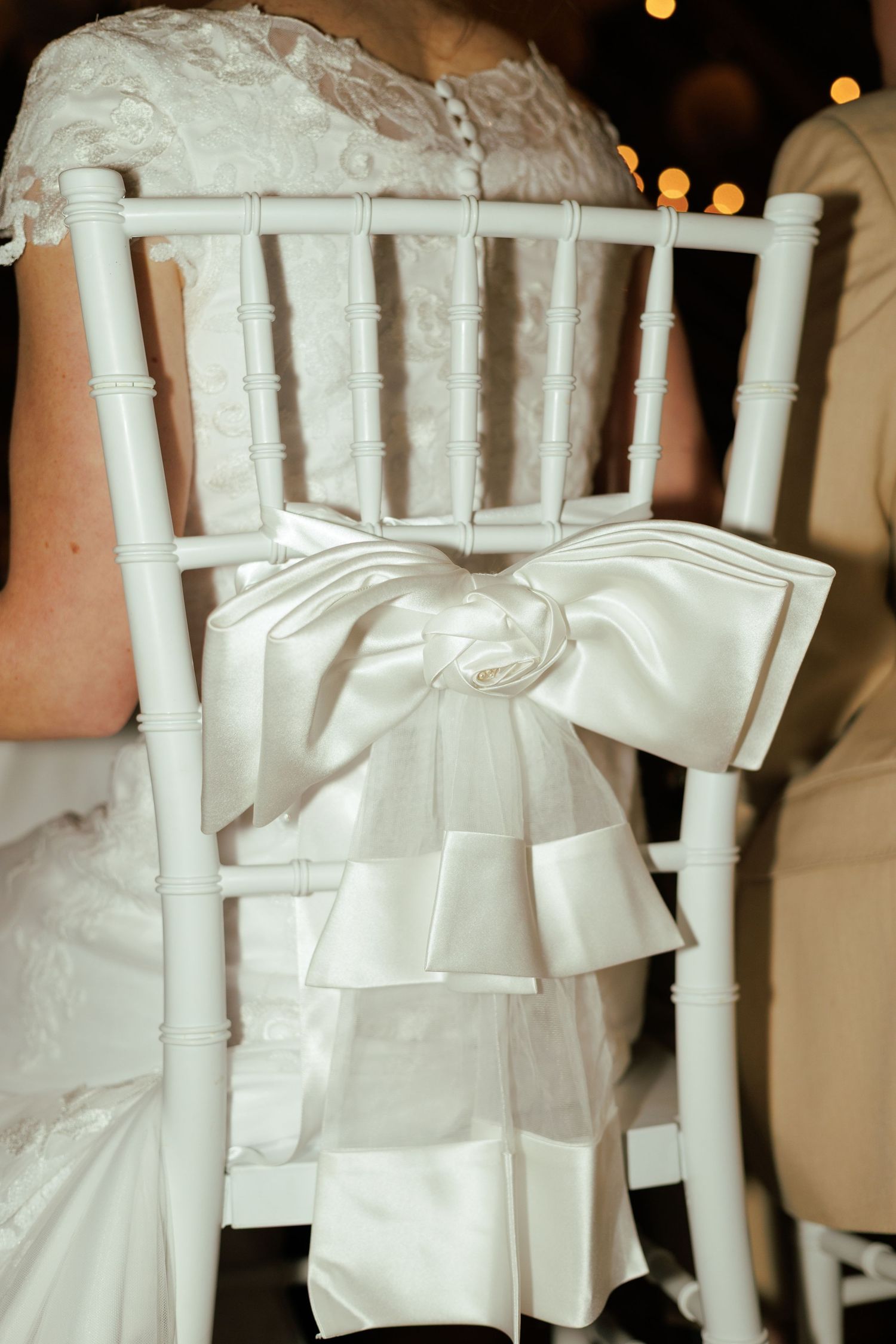 Row of white chairs decorated with elegant bows for a wedding ceremony in Ohio.