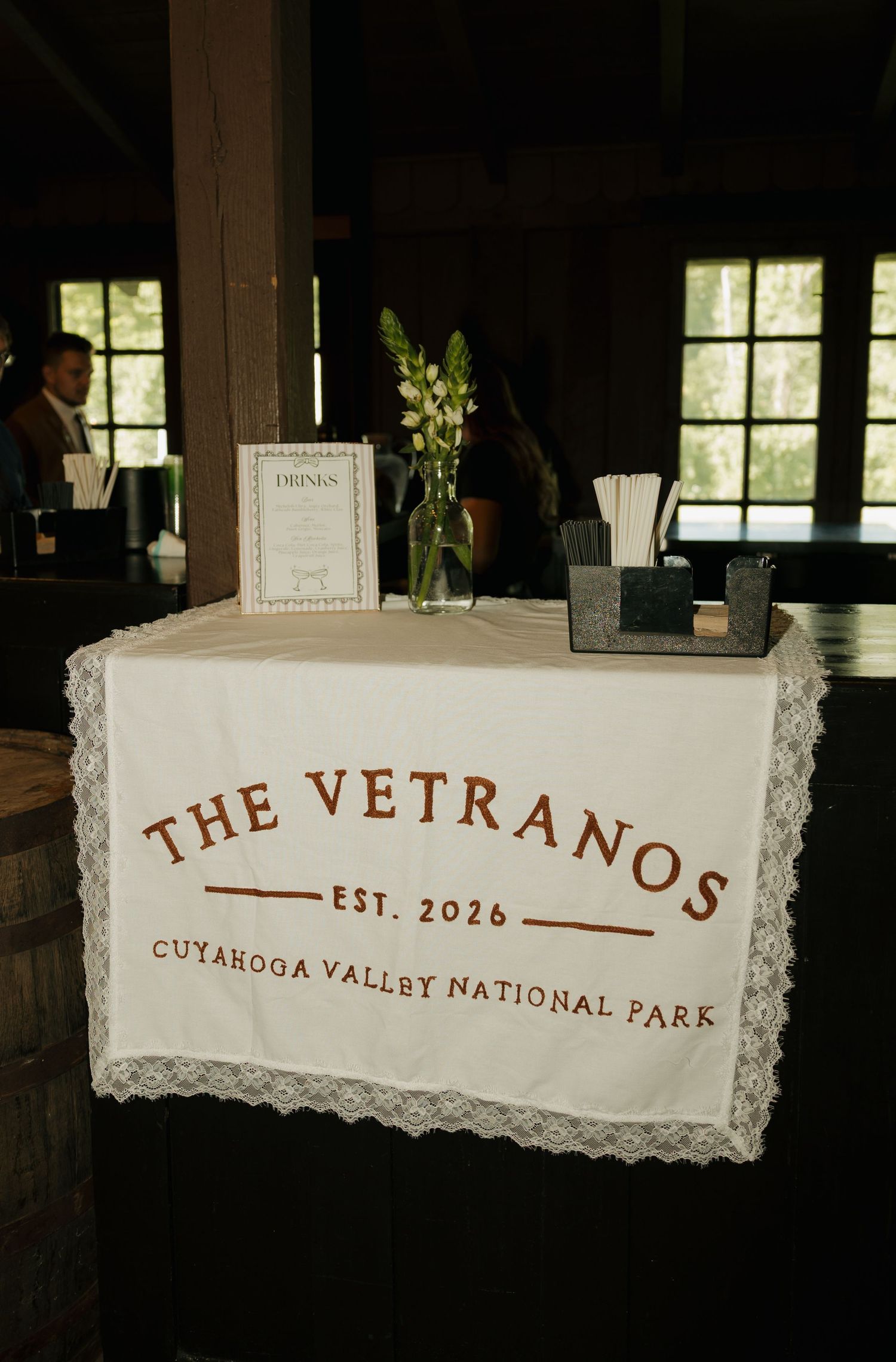 Wedding bar table with lace runner reading The Vetranos Est. 2026 Cuyahoga Valley National Park.