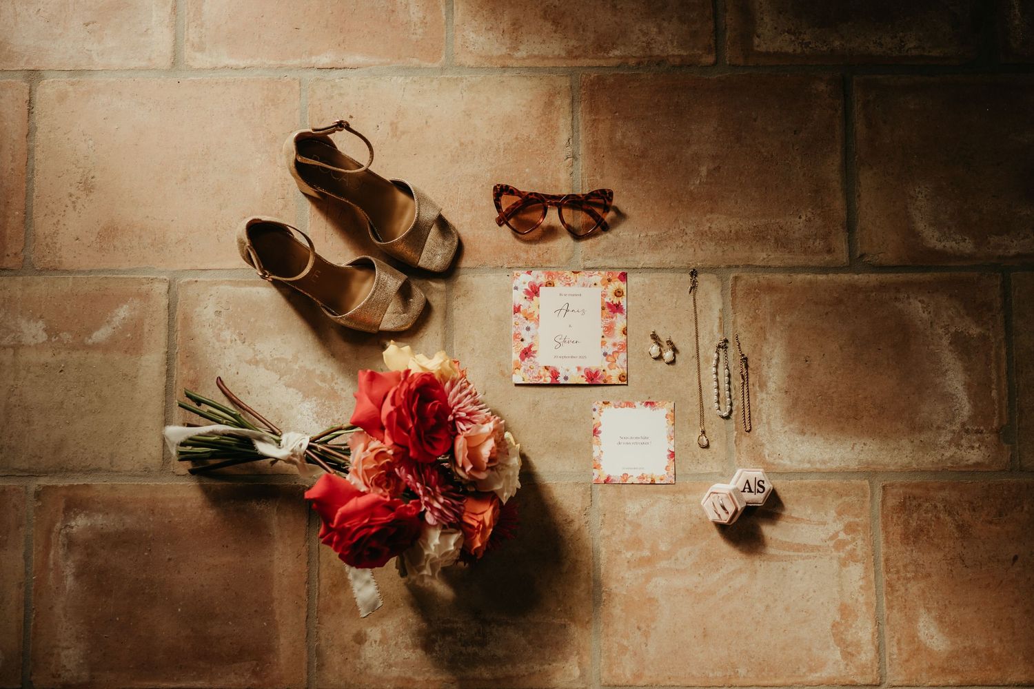 Accessoires et détails de mariée, posés dans un rayon de soleil sur la tomette du Domaine Saint Nicolas à Montech