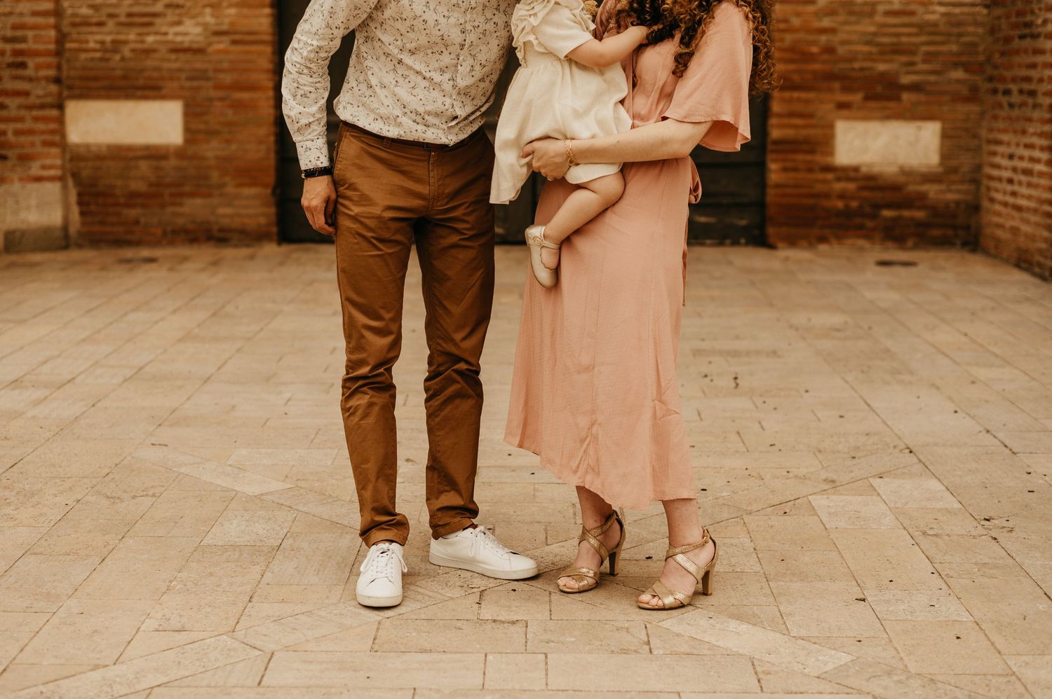 Portrait de famille avant la cérémonie de baptême, l'enfant en robe blanche, devant la Cathédrale Saint Alain de Lavaur