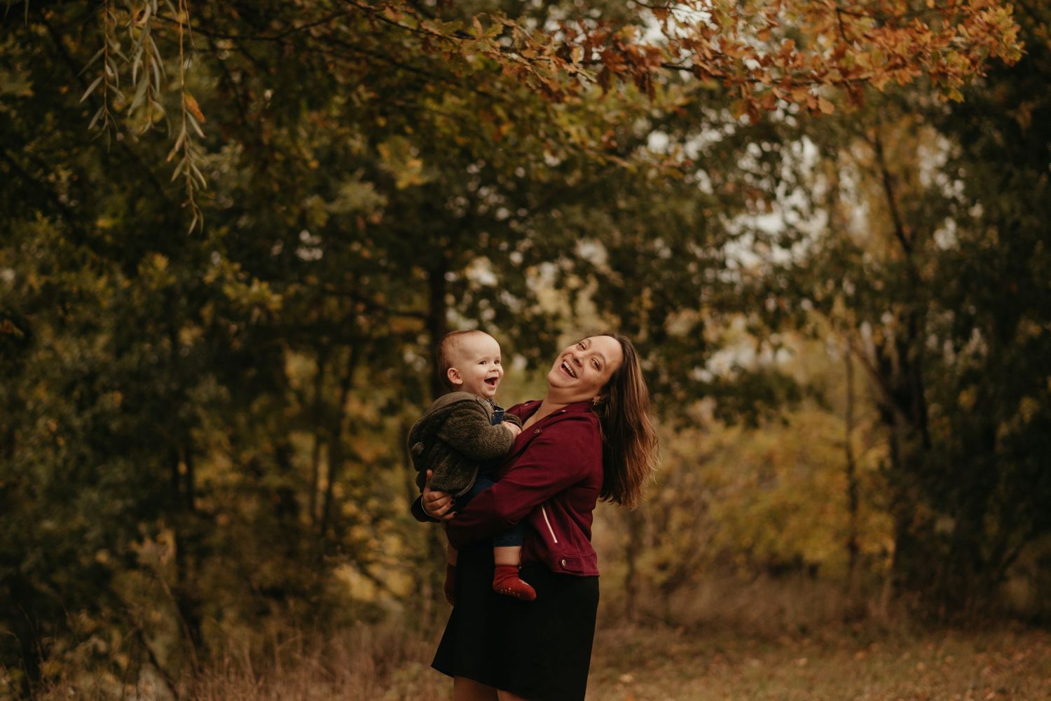 Maman et bébé riant ensemble, pendant un moment complice, en séance famille pendant l'automne, à Lavaur