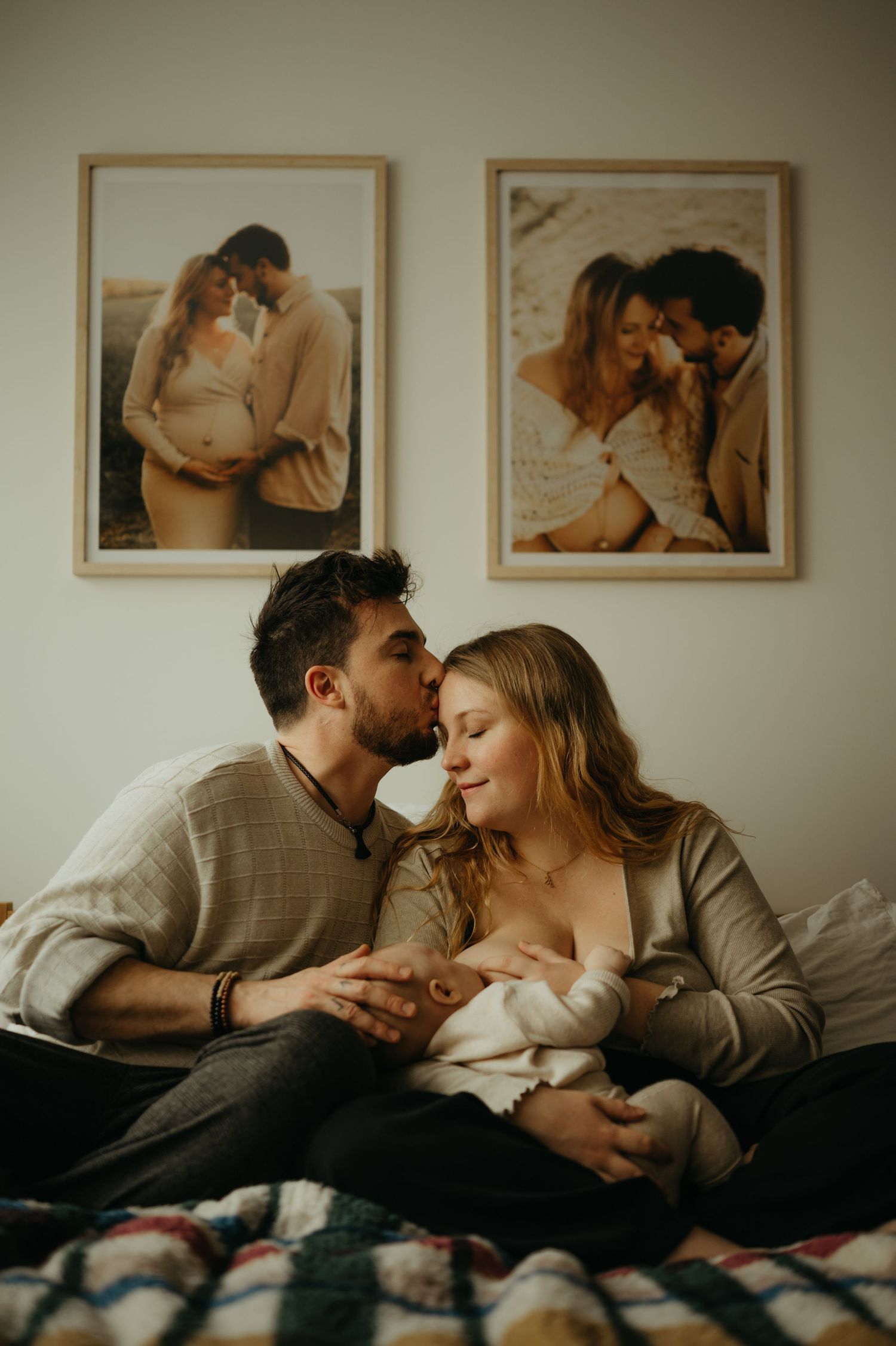 Un couple romantique partage des moments intimes, assis ensemble dans leur lit sous de douces couvertures avec leur bébé en séance lifestyle