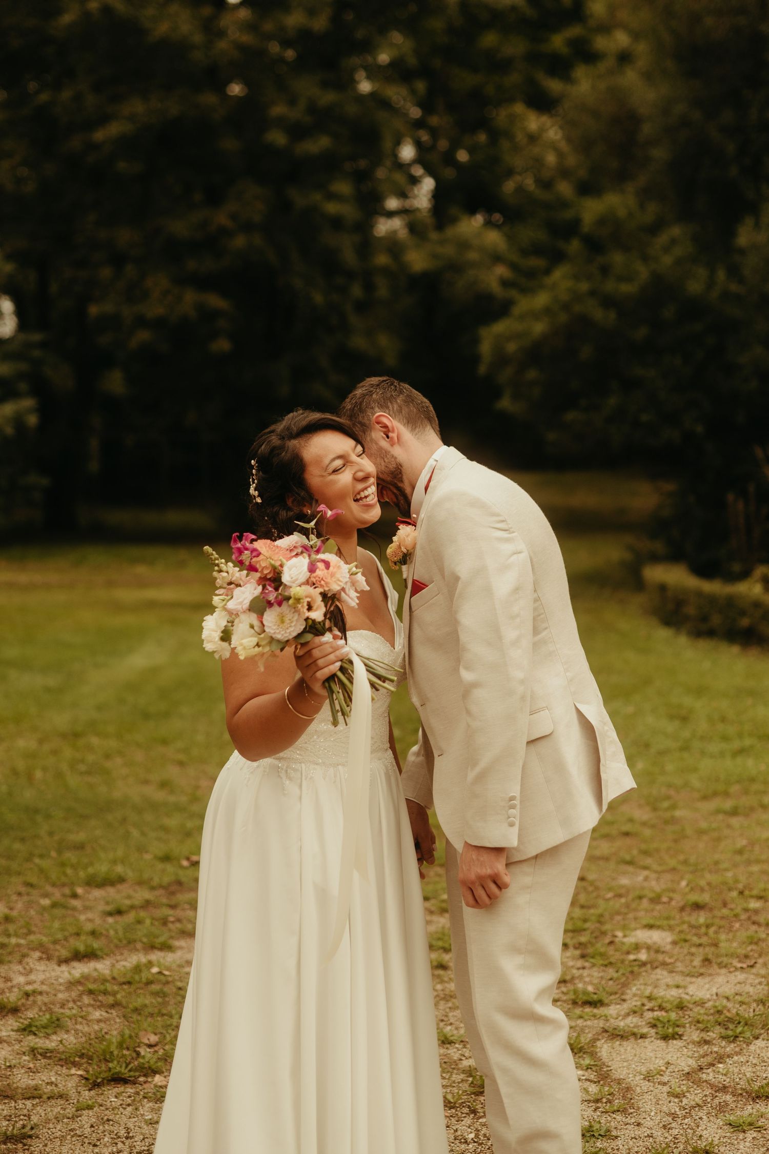 Marié qui chuchote à l'oreille de sa femme, souriant avec son bouquet à la main, à Lavaur