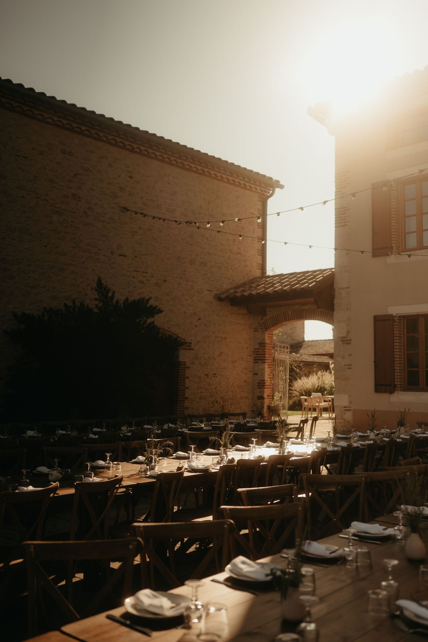 Tables type banquet, disposées dans la cour du Domaine Terra Rosa proche d'Albi