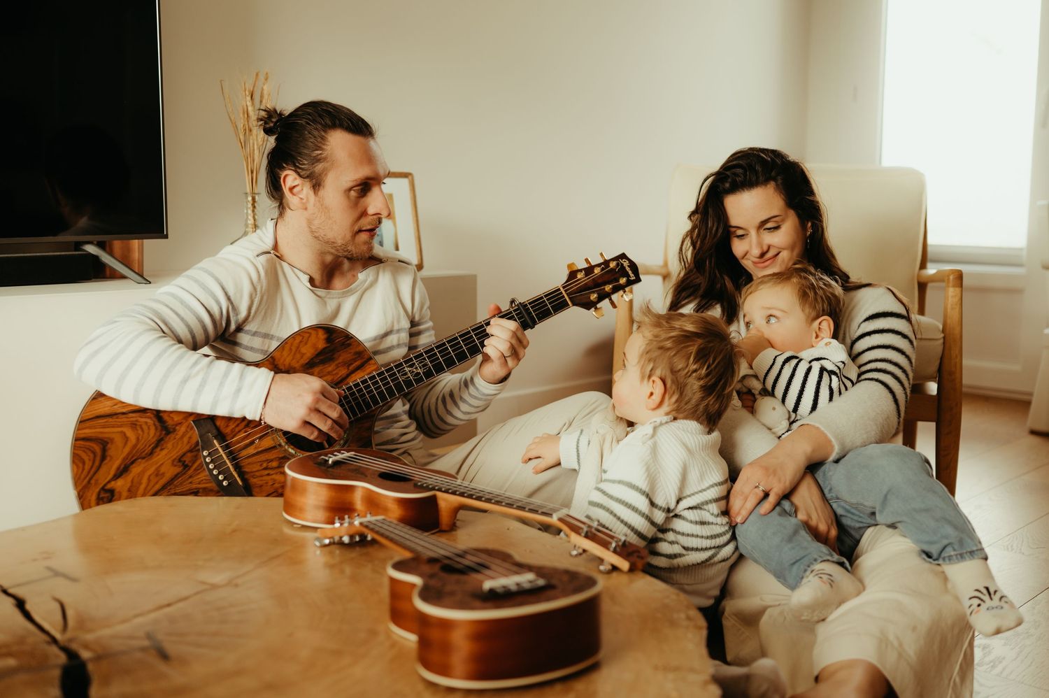 Séance famille, papa jouant de la guitare pour ses enfants et sa femme, à la maison, à Albi