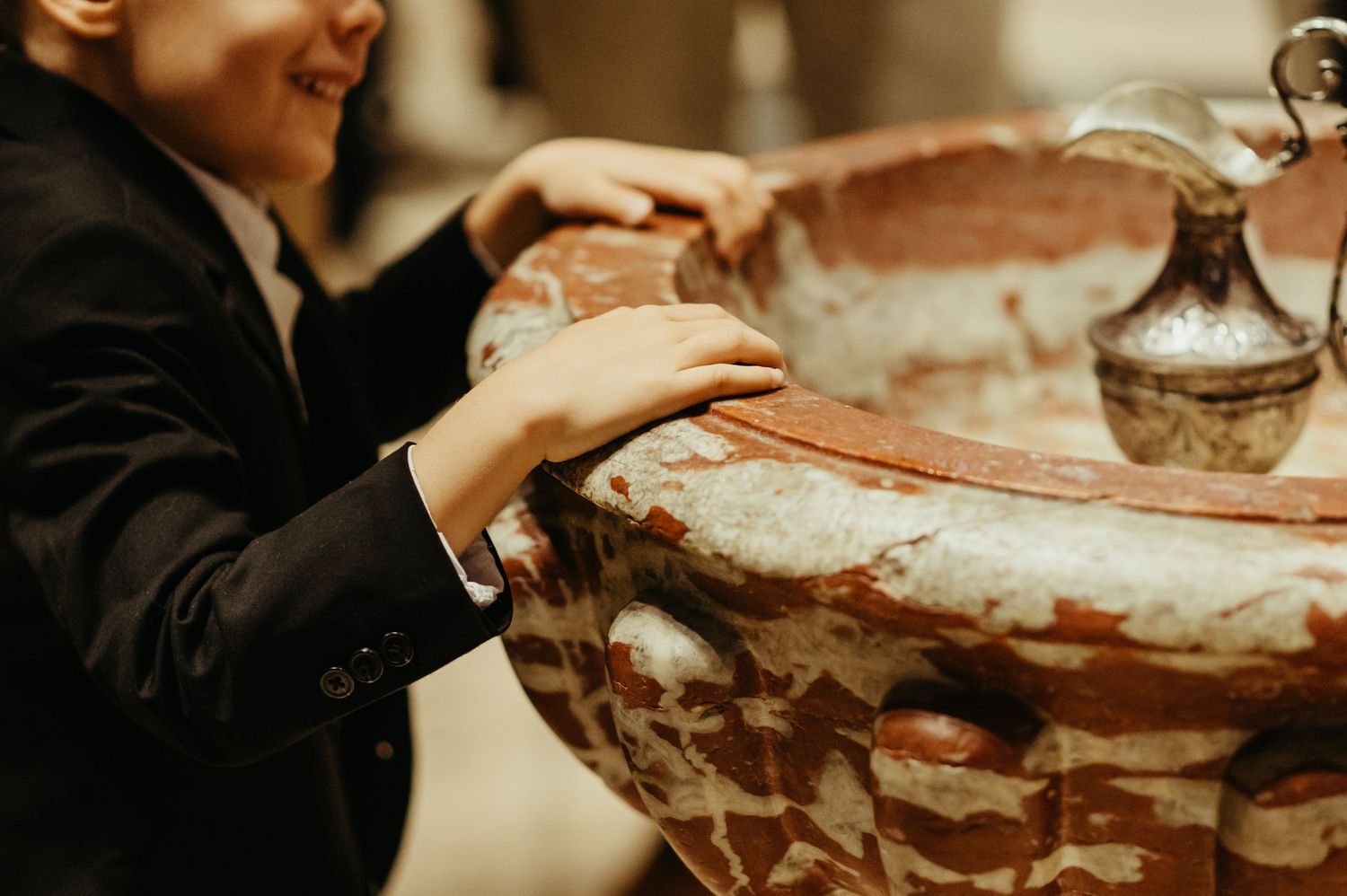 Détail de mains d'enfants pendant un Baptême à Notre Dame de la Drêche à Cagnac les Mines