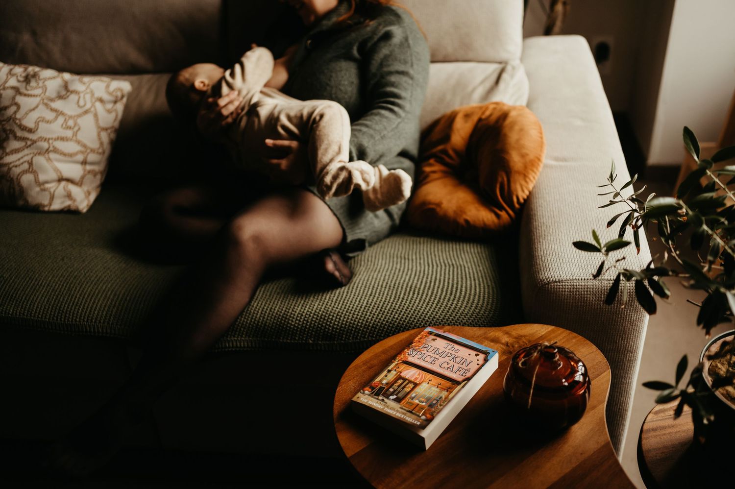 Maman avec son bébé, dans son salon cosy avec un éclairage chaud et tamisé créant une atmosphère intime, à Gaillac