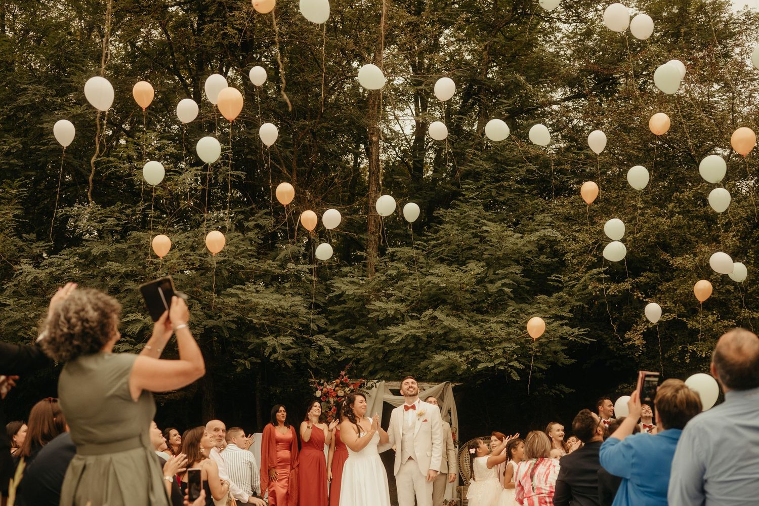 Famille, amis et mariés pendant un lâcher de ballons, à la fin de leur cérémonie, près de Lavaur