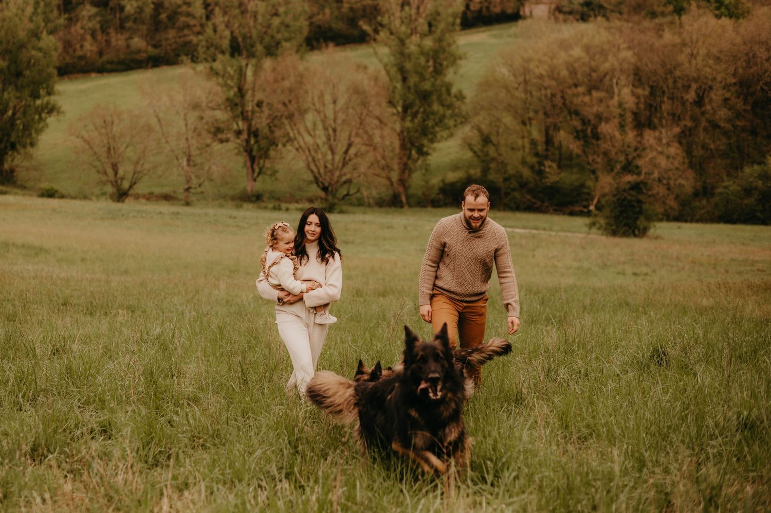 Une famille traverse un champ d'automne lors d'une séance photo à l'heure dorée à Gaillac