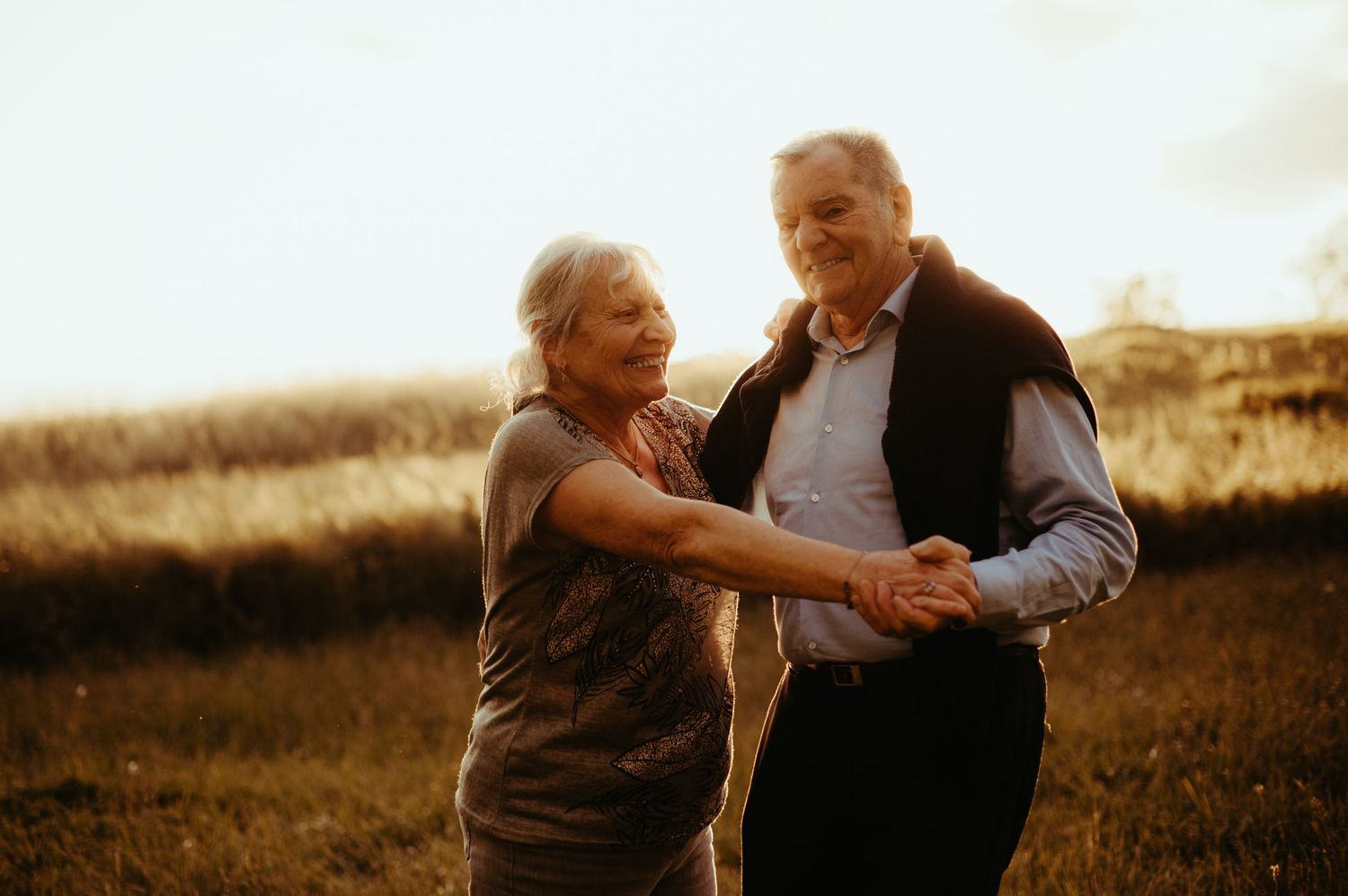 Grands-parents souriant pendant une danse au coucher du soleil, en séance famille à Albi