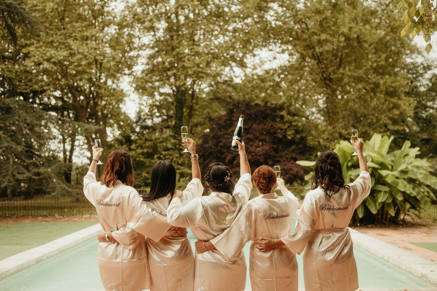 Amies de la mariée et la mariée, partageant une coupe de champagne devant une piscine, à Lavaur