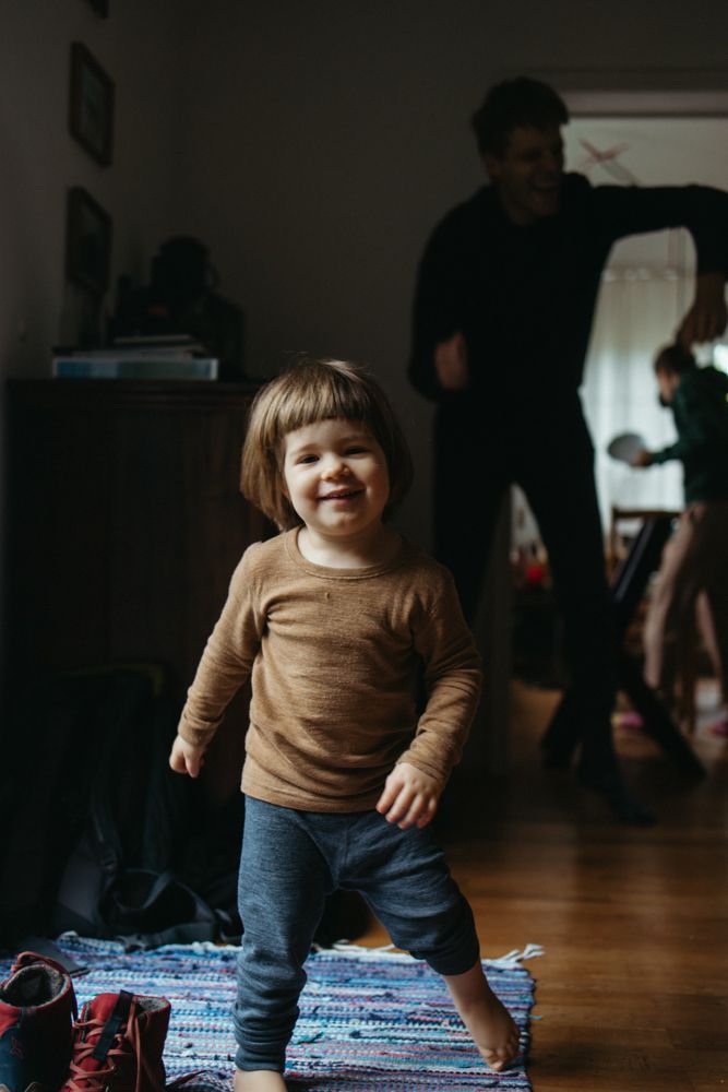 Tochter und Papa tanzen wild umher bei einem Familienfotoshooting