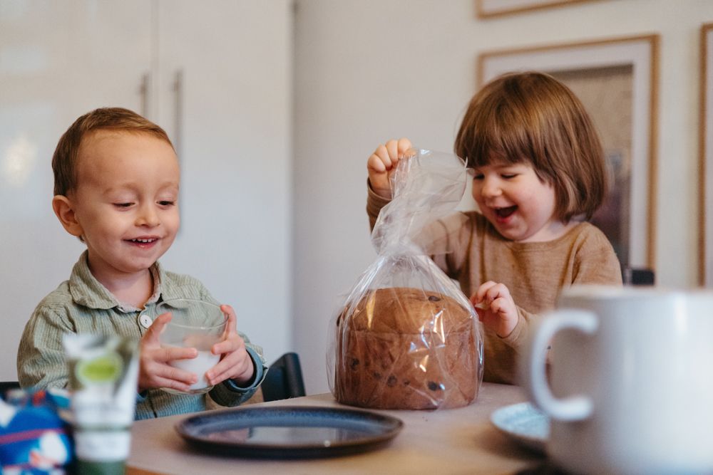 Bei einem Familien.Fotoshooting in Offenburg freuen sich Kinder daran einen Kuchen auszupacken und lachen dabei