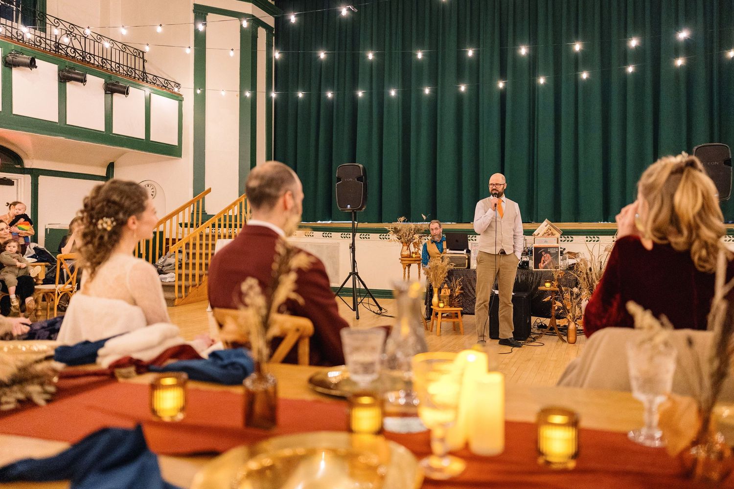 A candlelit yoga studio with people practicing meditation on mats during an evening wellness session.