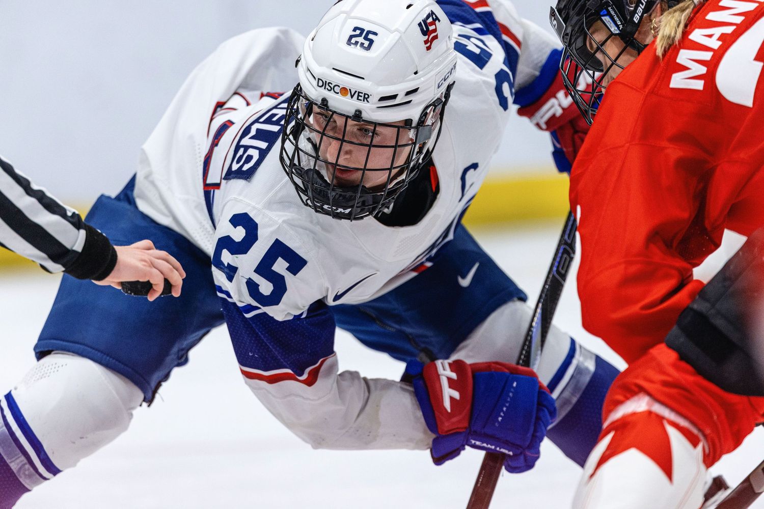 Hockey players from opposing teams battle for the puck during an intense game on the ice.