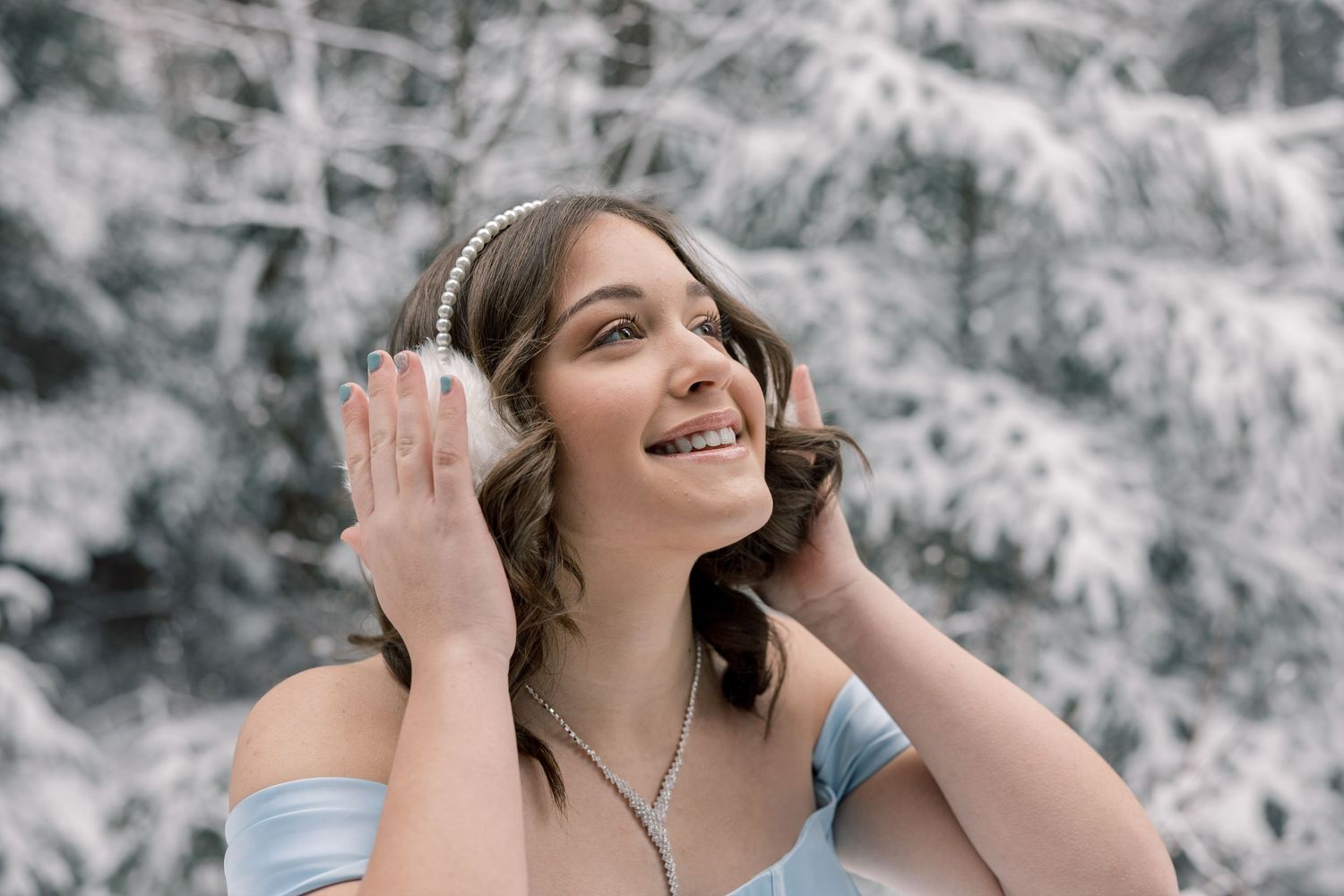 A person wearing headphones dances joyfully in a snowy winter setting.
