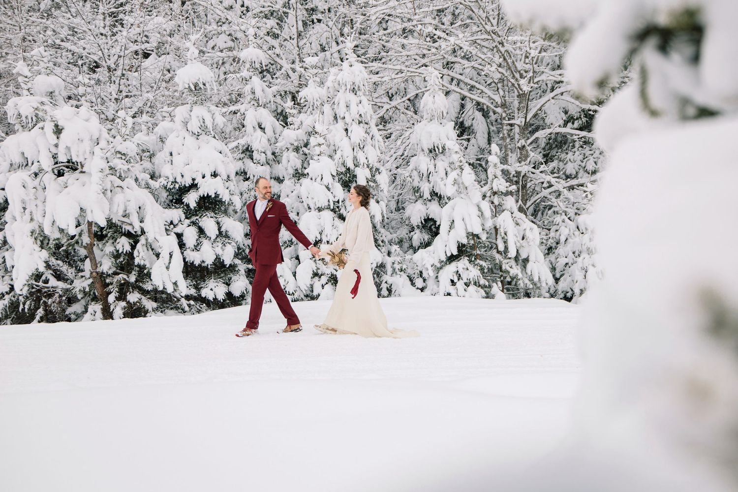 A group of people walking through a snowy winter wonderland with snow-covered trees and paths.