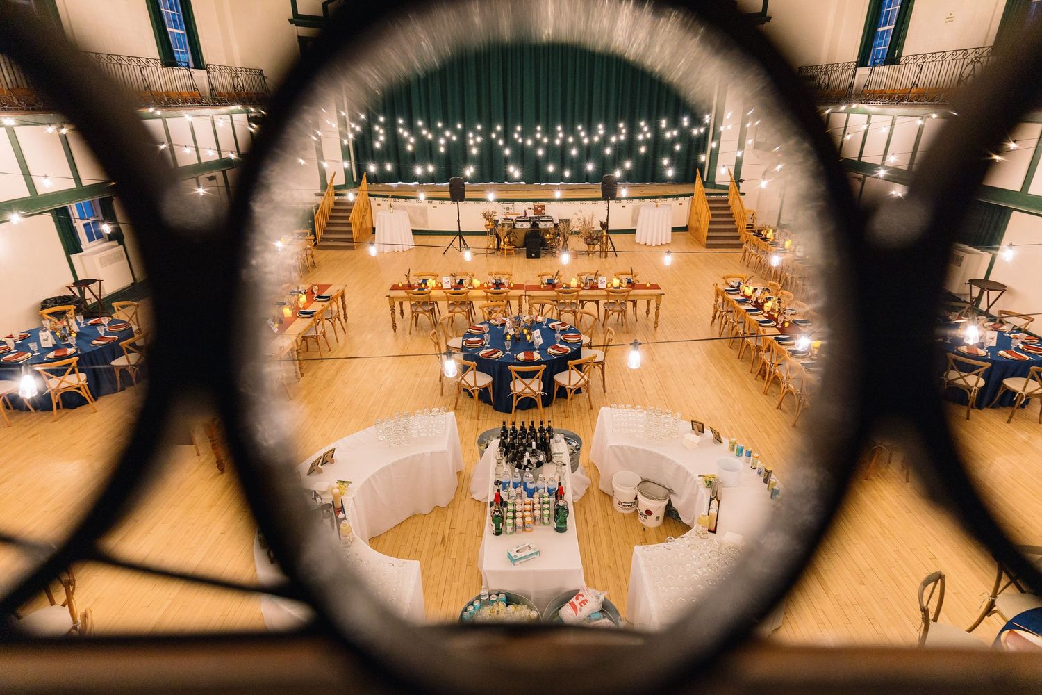 View through an architectural detail of a large concert hall with choir and orchestra setup on stage.