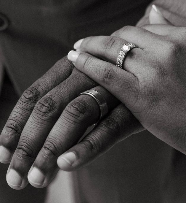 Photo of couples hand and wedding ring