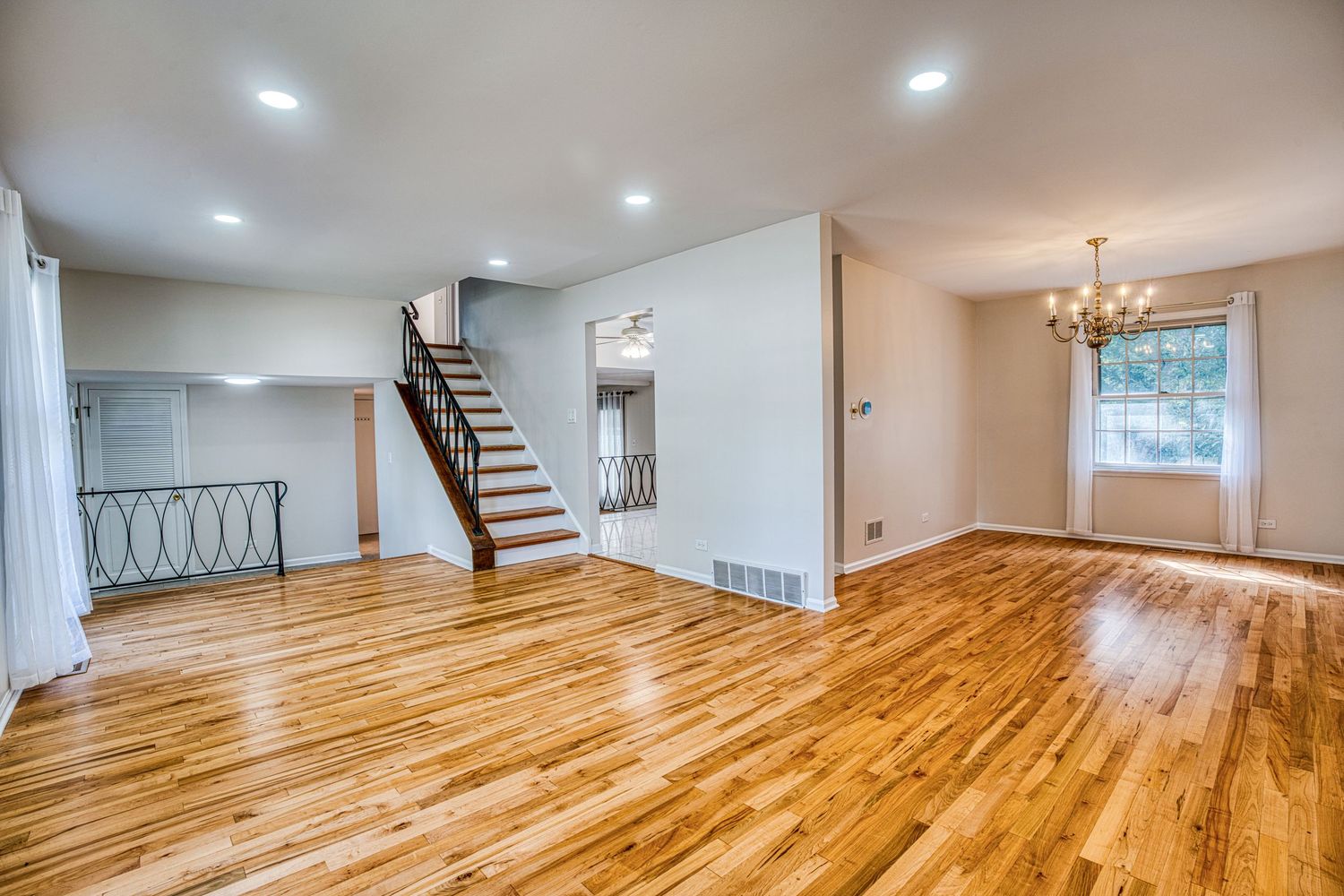 Open concept living space with gleaming hardwood floors and recessed lighting throughout.