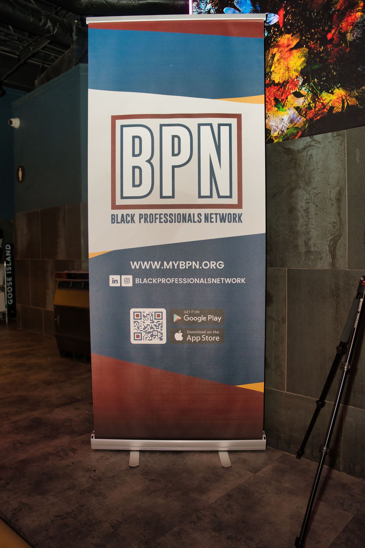 A retractable banner stand displays the BPN (Black Professionals Network) logo and website information at a networking event.