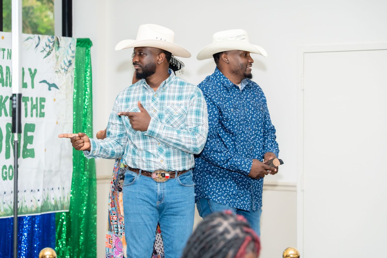 People in western attire gather at a white and green painted venue for a social event.