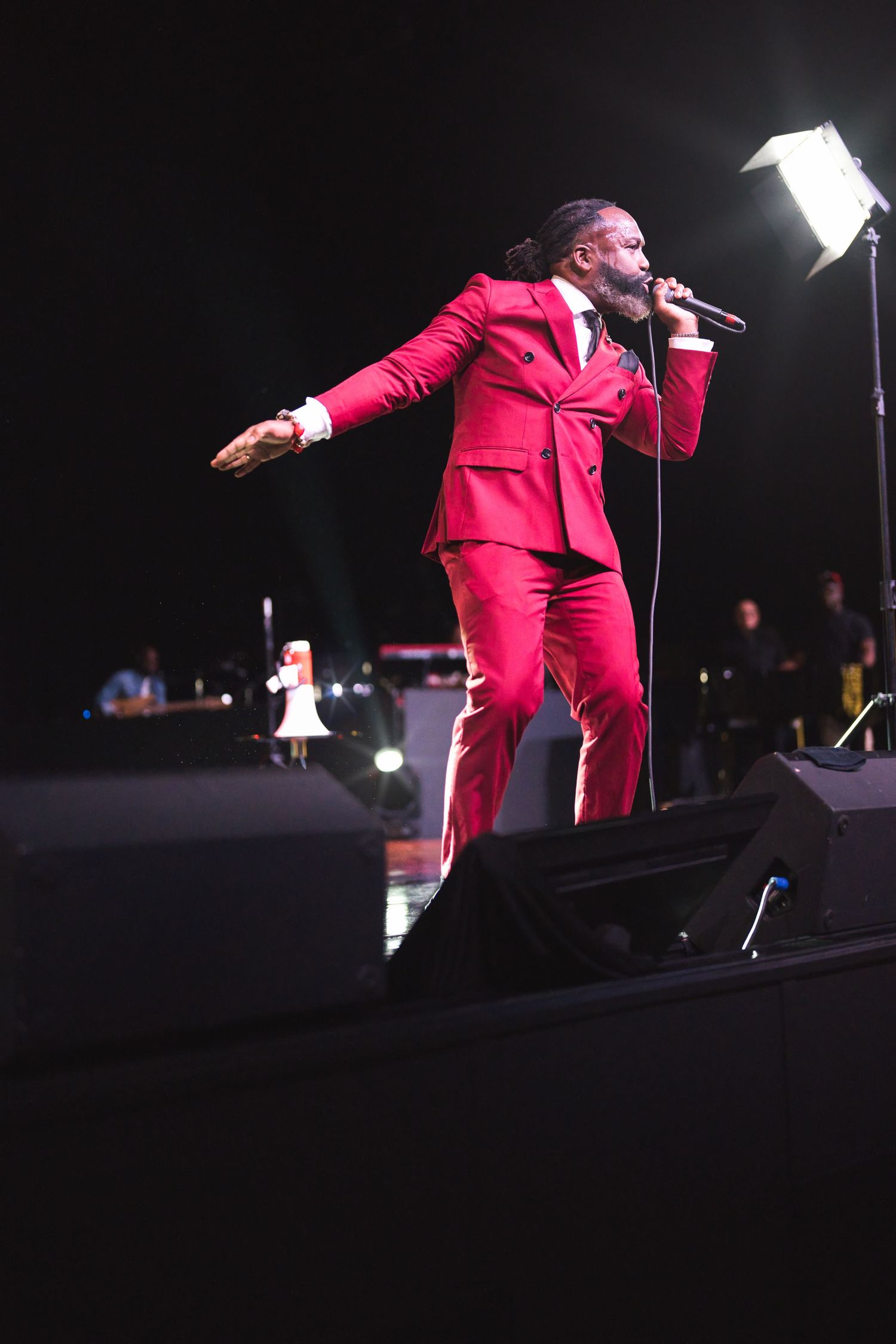 Energetic stage performance in red suit showing dynamic movement.