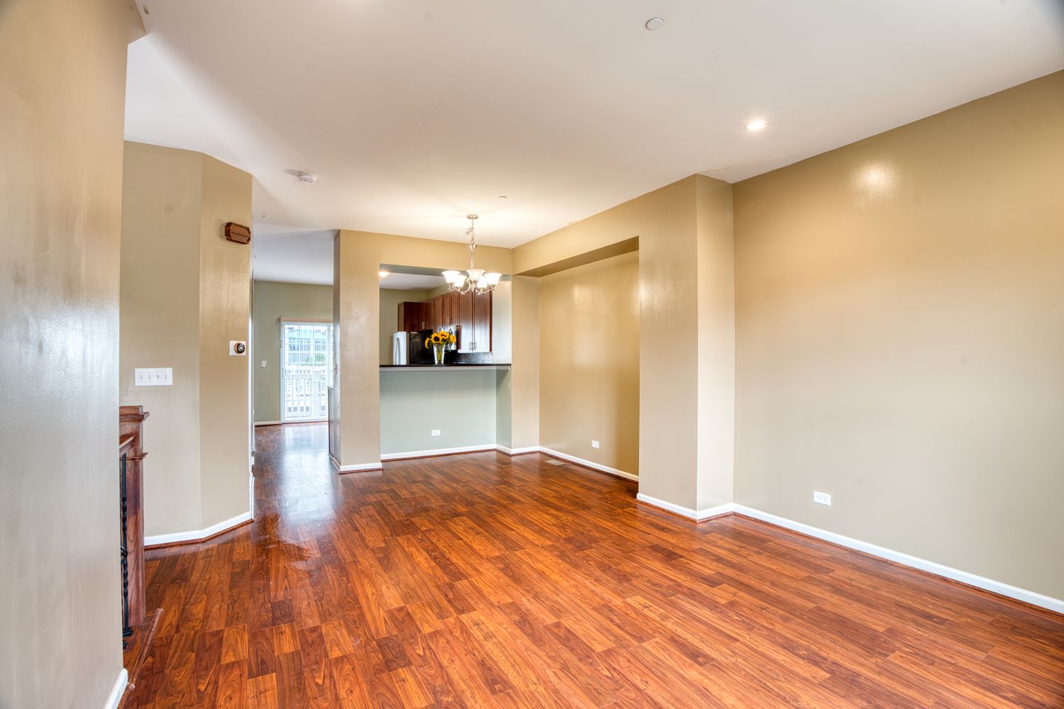 Open concept living area with hardwood floors, beige walls, and recessed lighting.