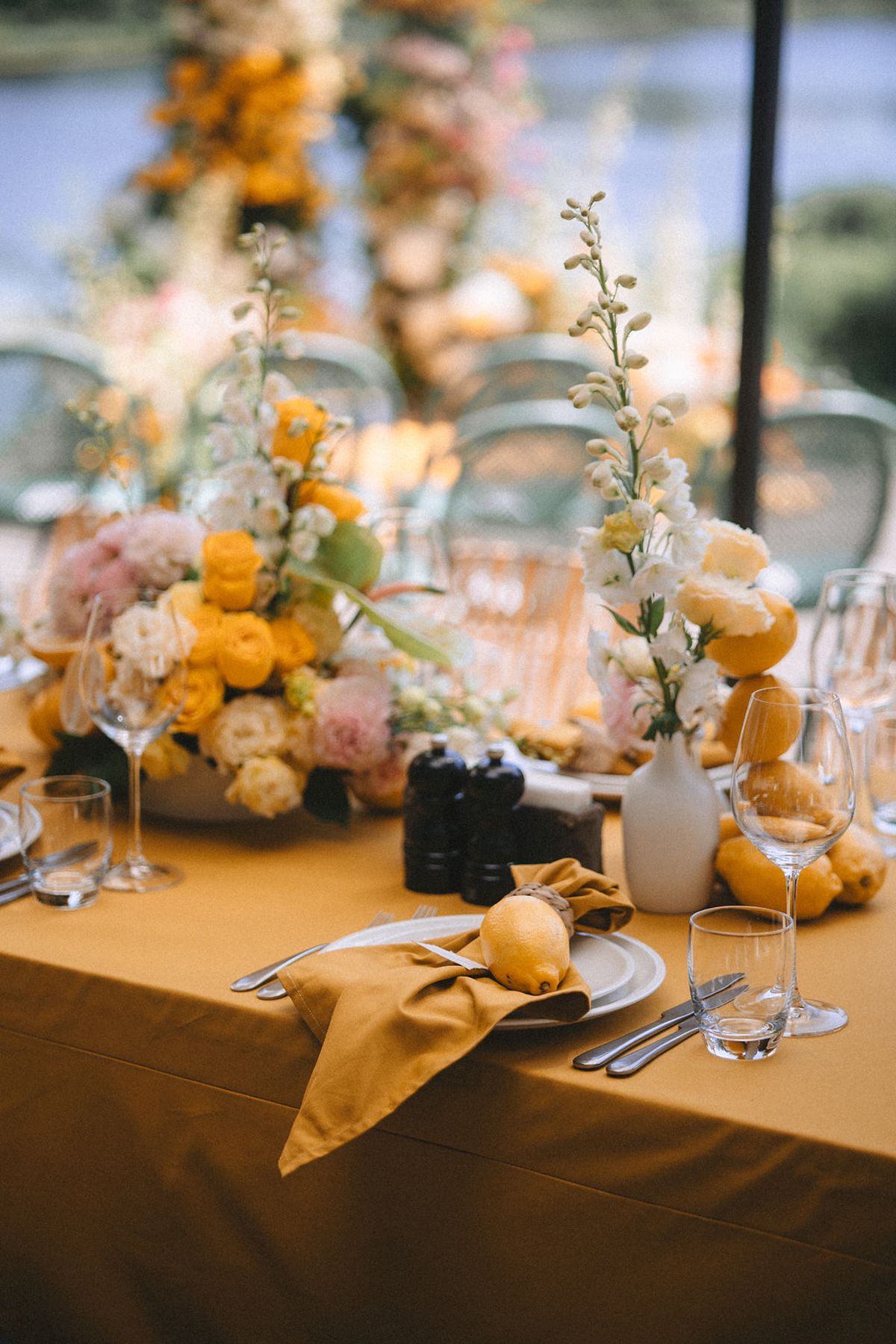 Elegant wedding reception table settings with soft peach and orange floral centerpieces and crystal glassware.