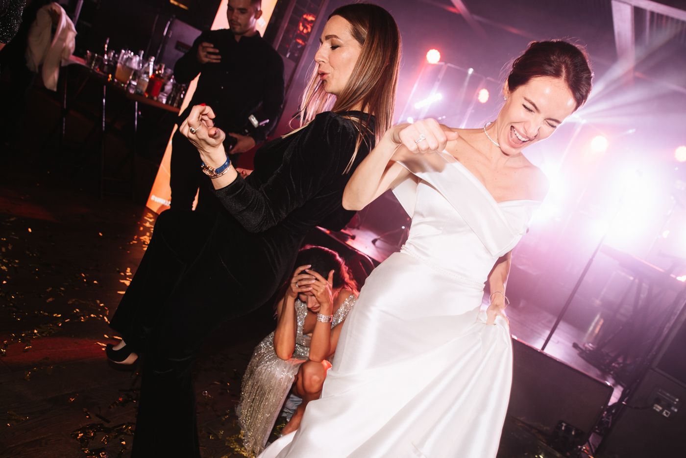 Wedding celebration with dancing and colorful lighting effects.