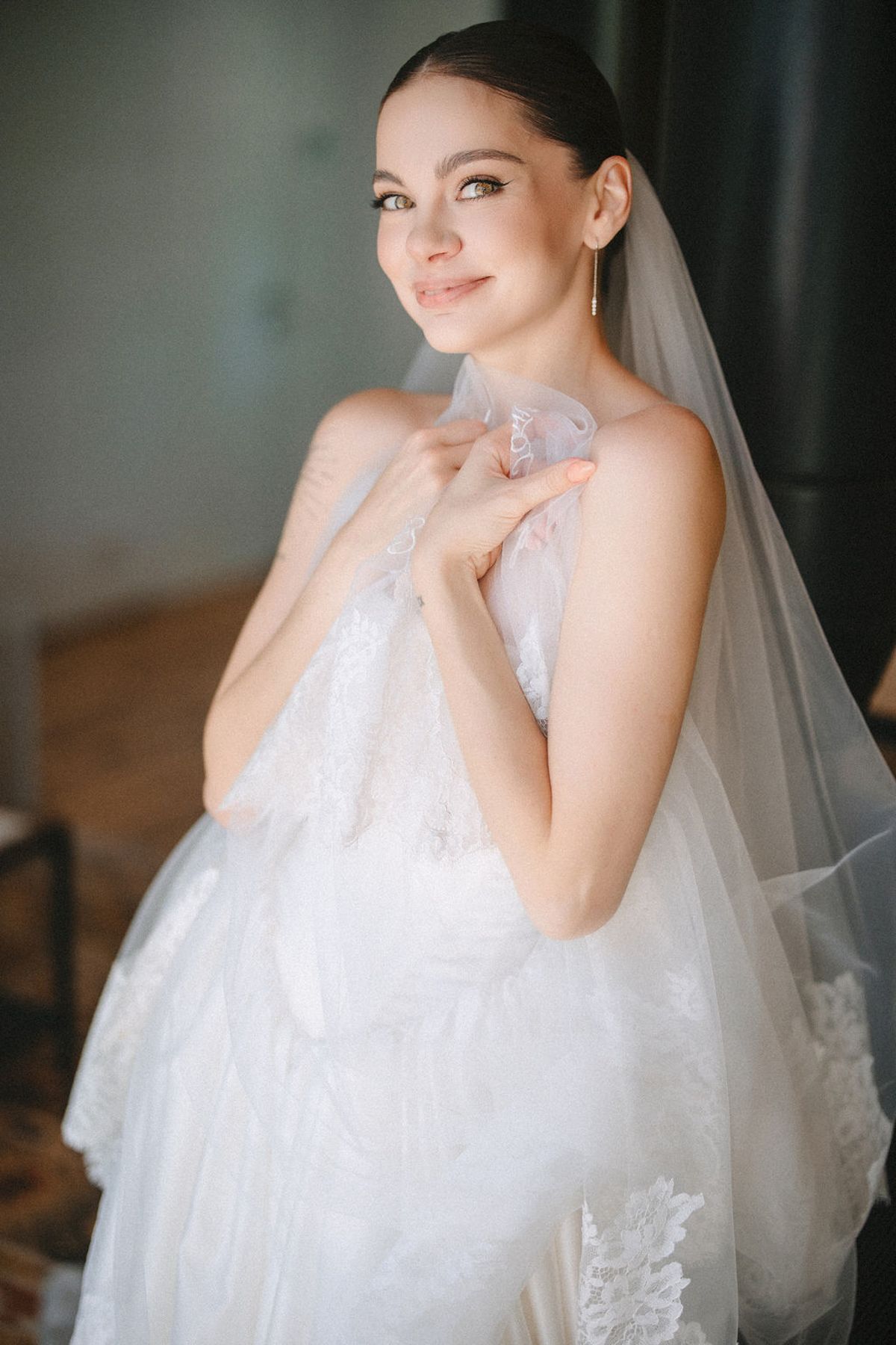 A bride in a flowing white wedding gown and veil poses gracefully in a series of elegant portraits.