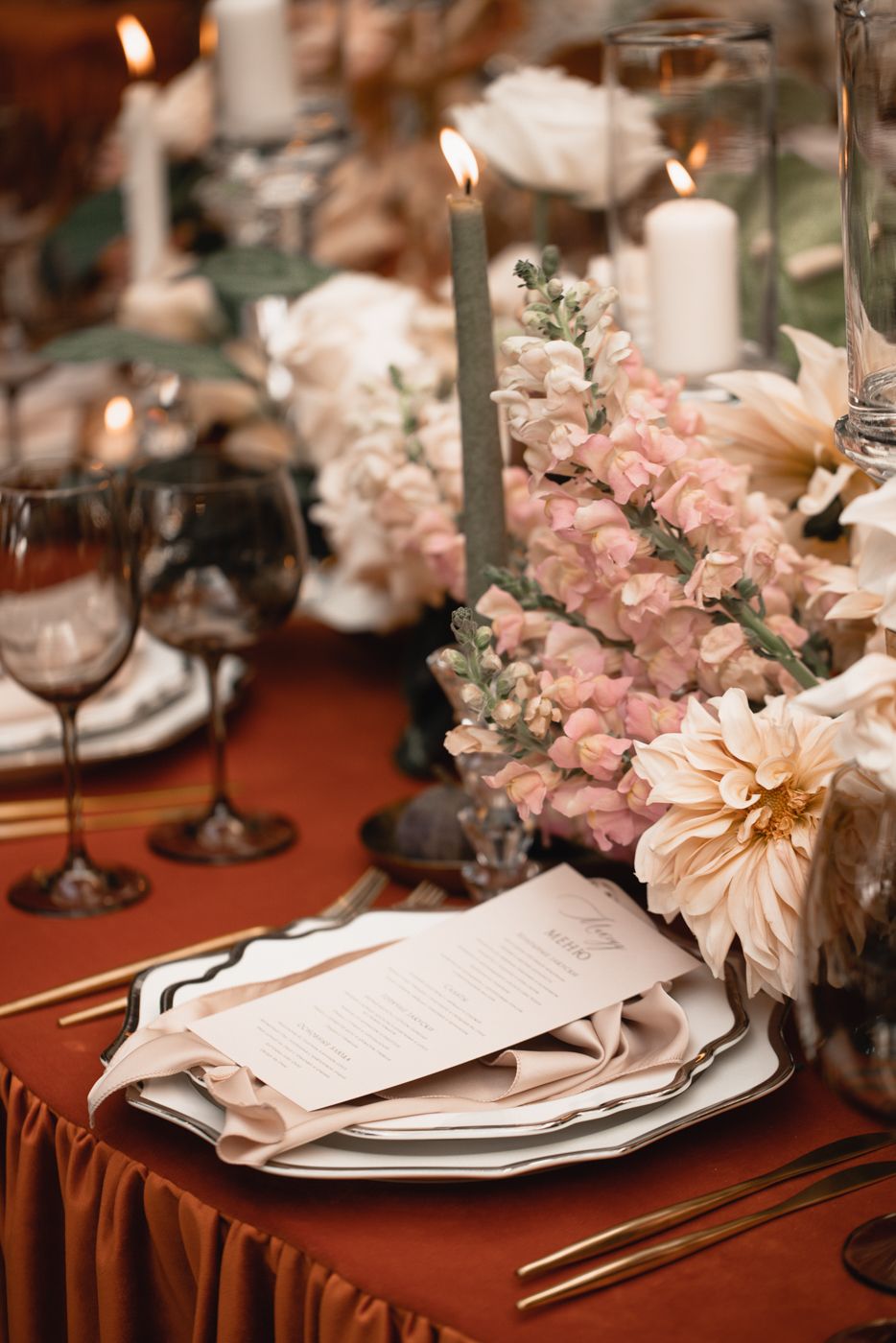 Romantic table setting with pink flowers, delicate place settings, and crystal glassware.