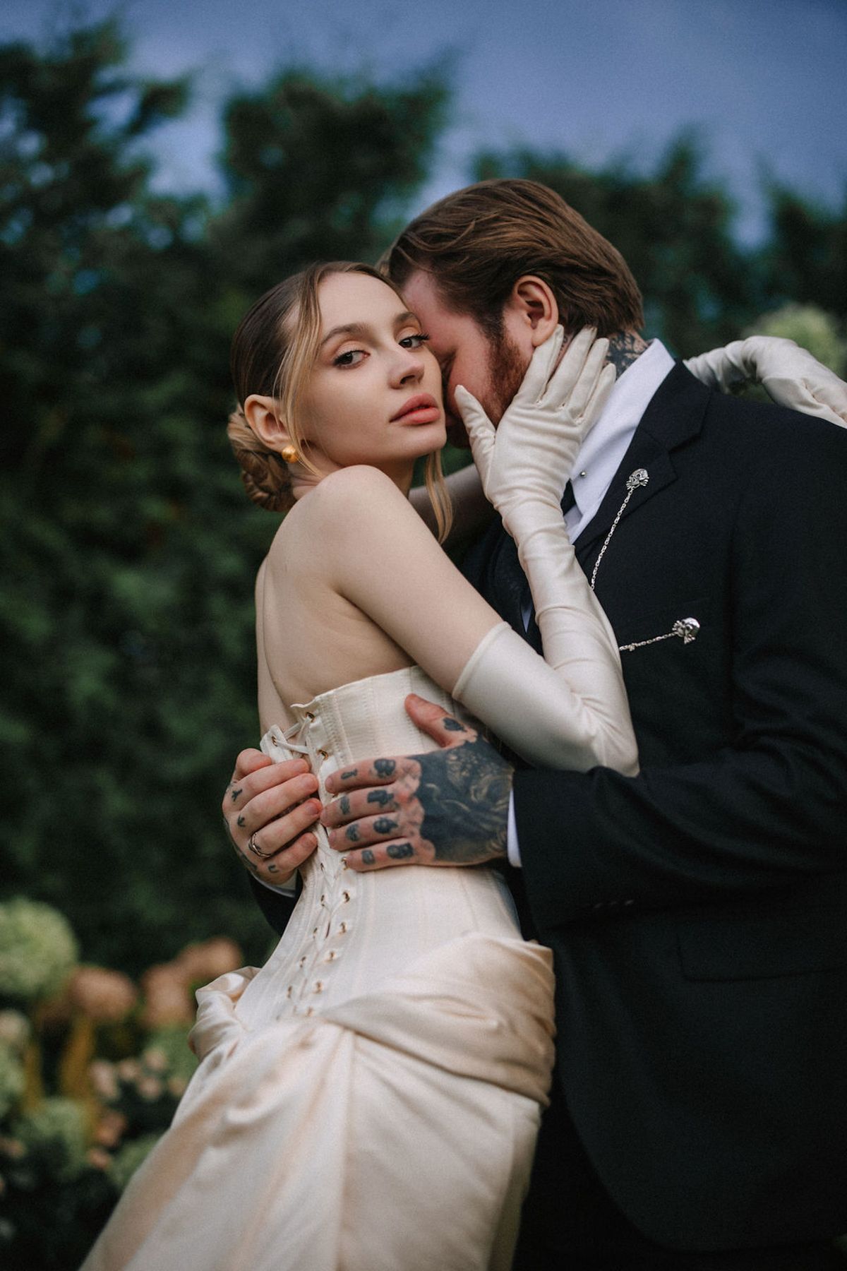 A romantic wedding couple embraces in an intimate outdoor portrait series against a natural garden backdrop.