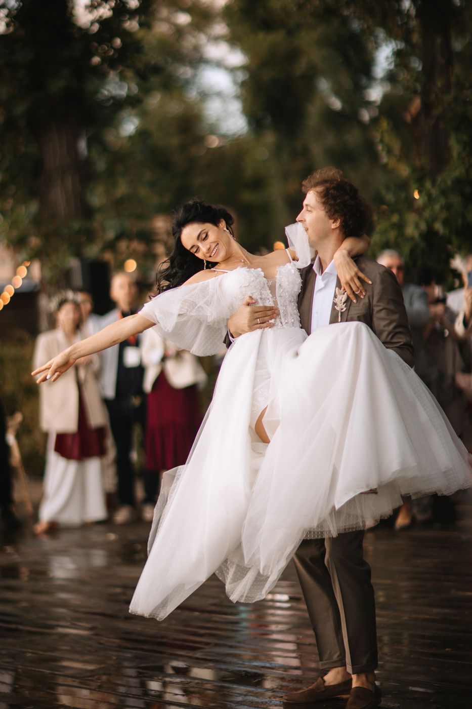 A romantic wedding dance scene outdoors with a bride in a flowing white dress and partner in a suit during golden hour.