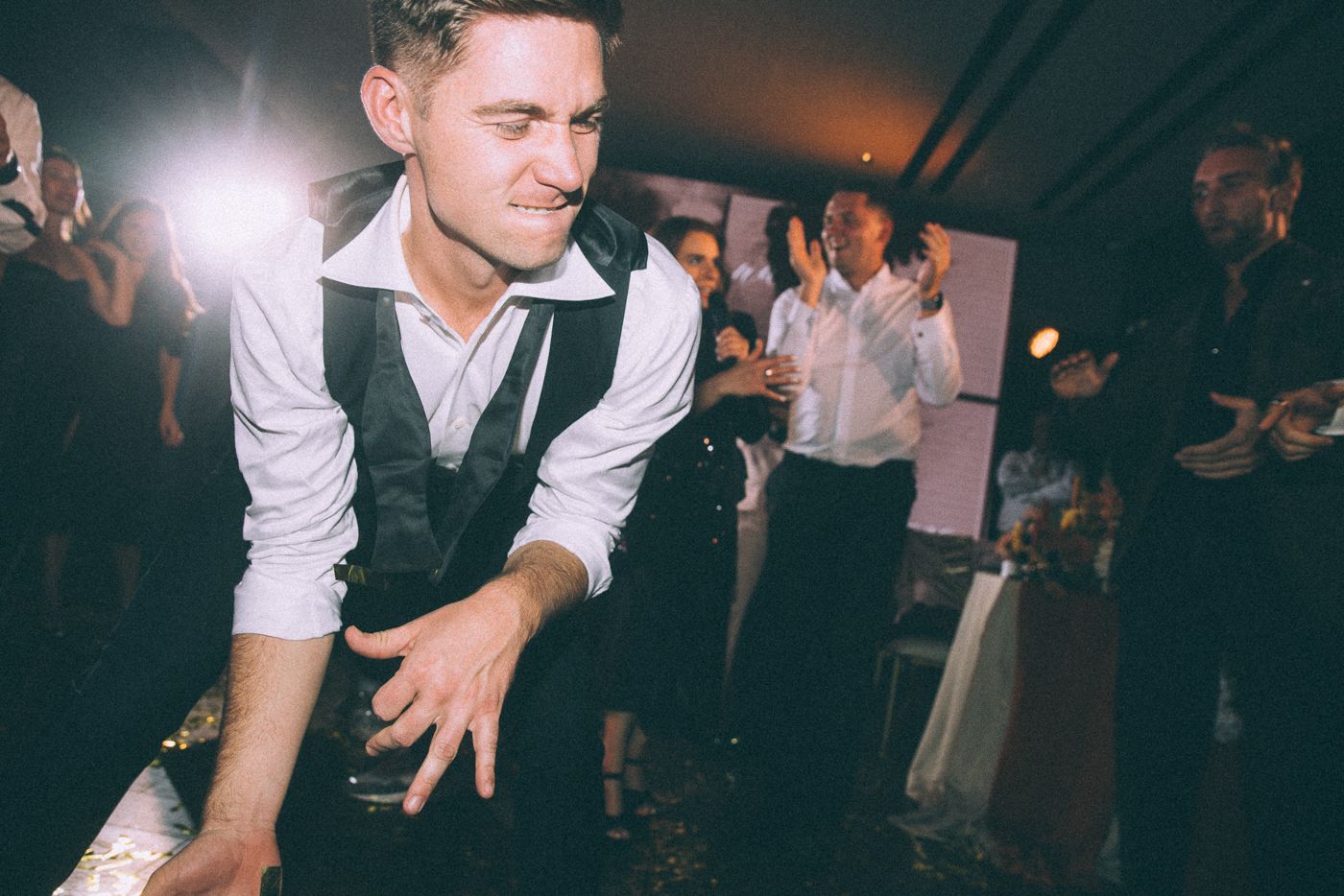 Wedding reception guests dancing and celebrating on a crowded dance floor.