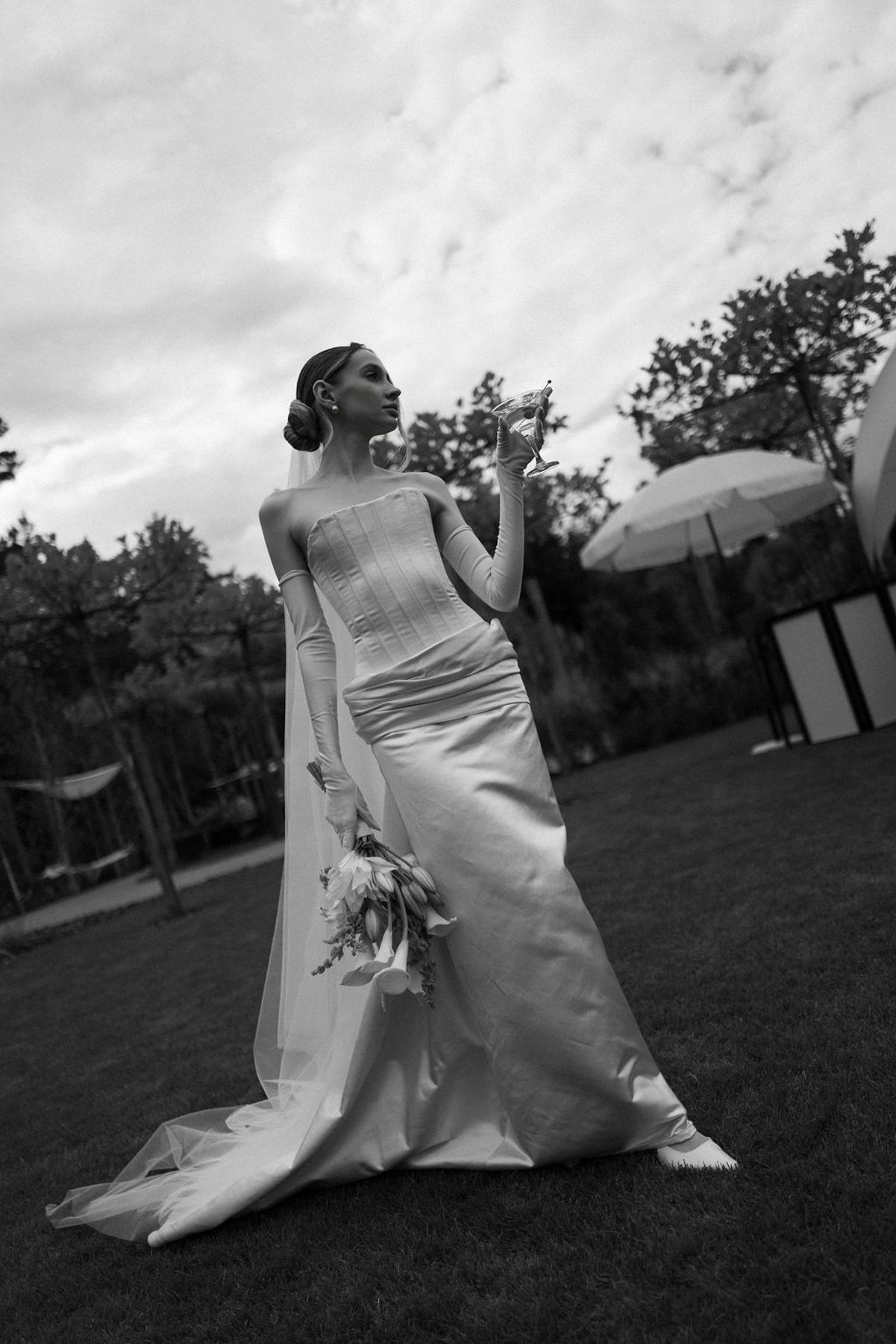 A sequence of artistic black and white photos showing a bride in a flowing wedding dress twirling in an outdoor garden setting.