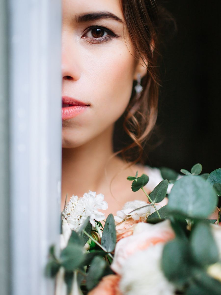 Close up artistic portrait with eucalyptus leaves and soft lighting creating a romantic mood.