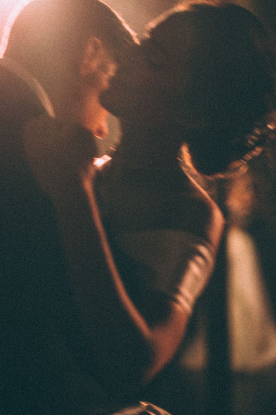 Silhouettes of people singing or performing in a dimly lit venue.