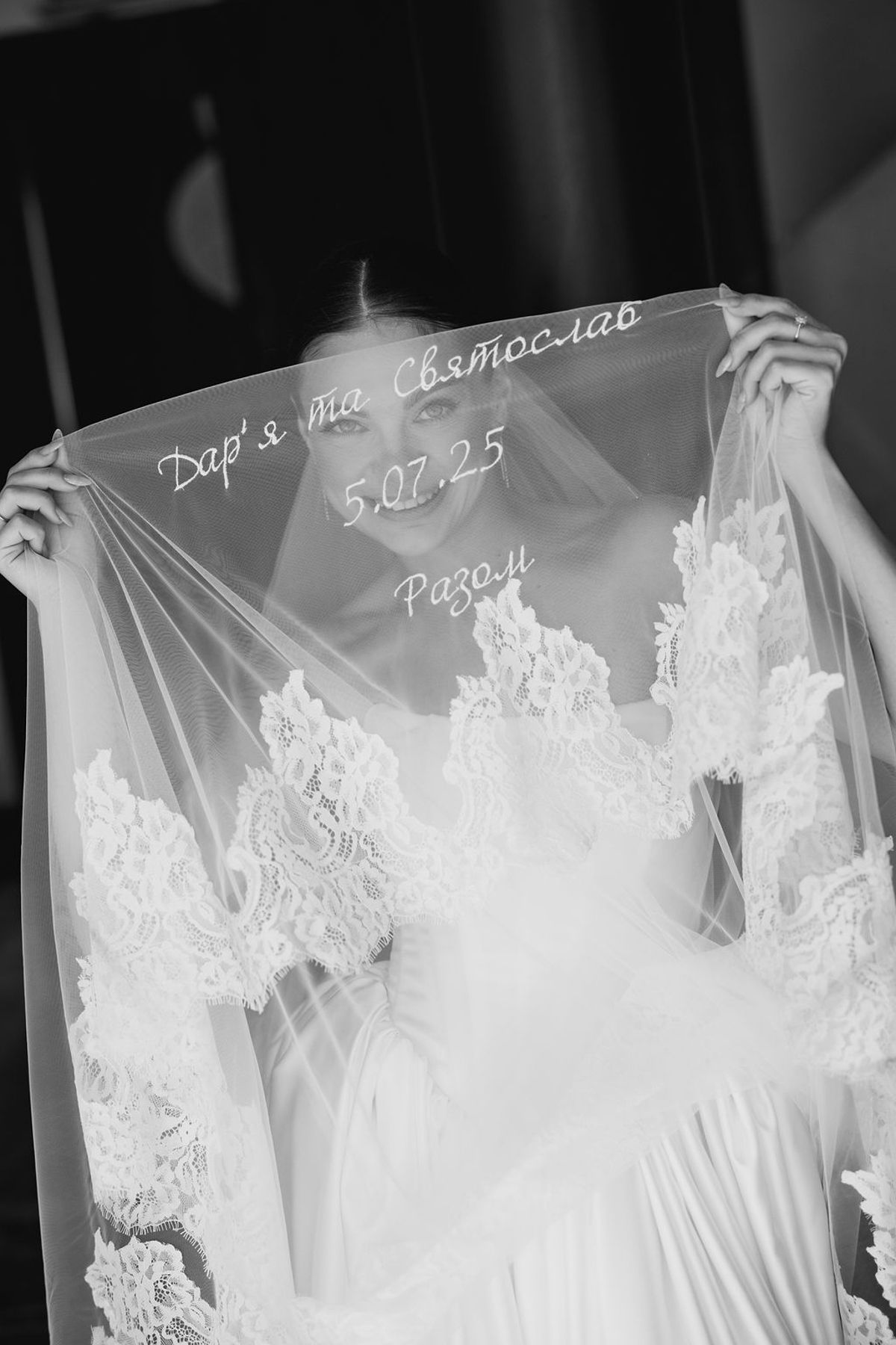 A row of elegant white wedding dresses with delicate lace details hanging on display in a bridal boutique.