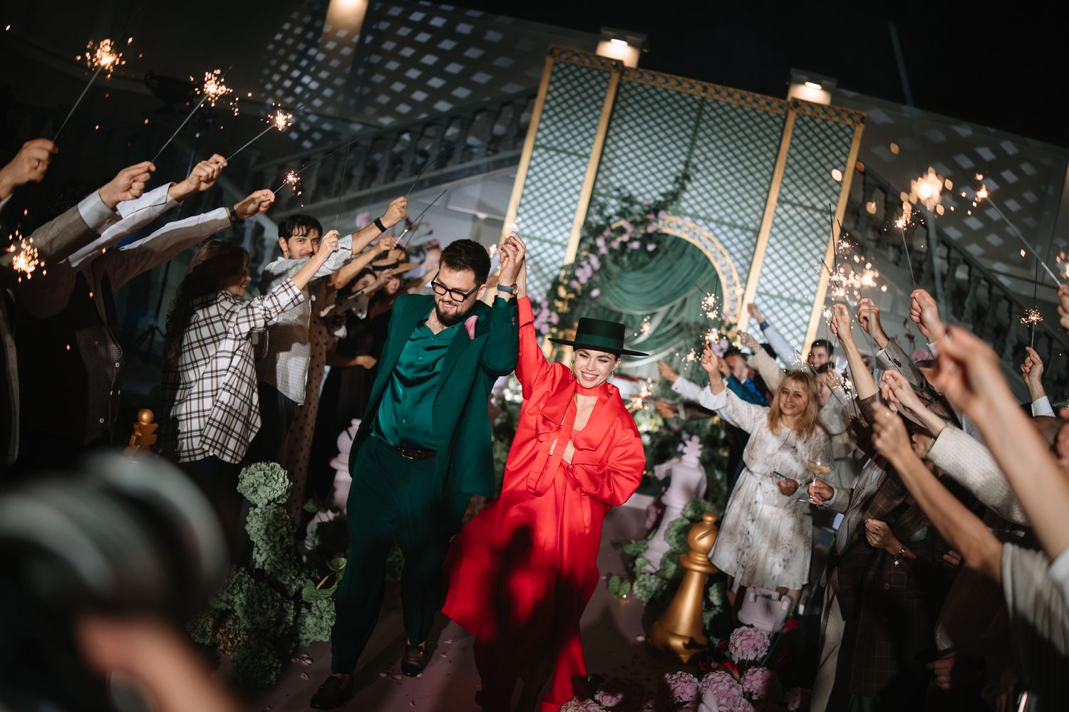Crowd of people dancing and celebrating with raised arms at a lively party or nightclub event.