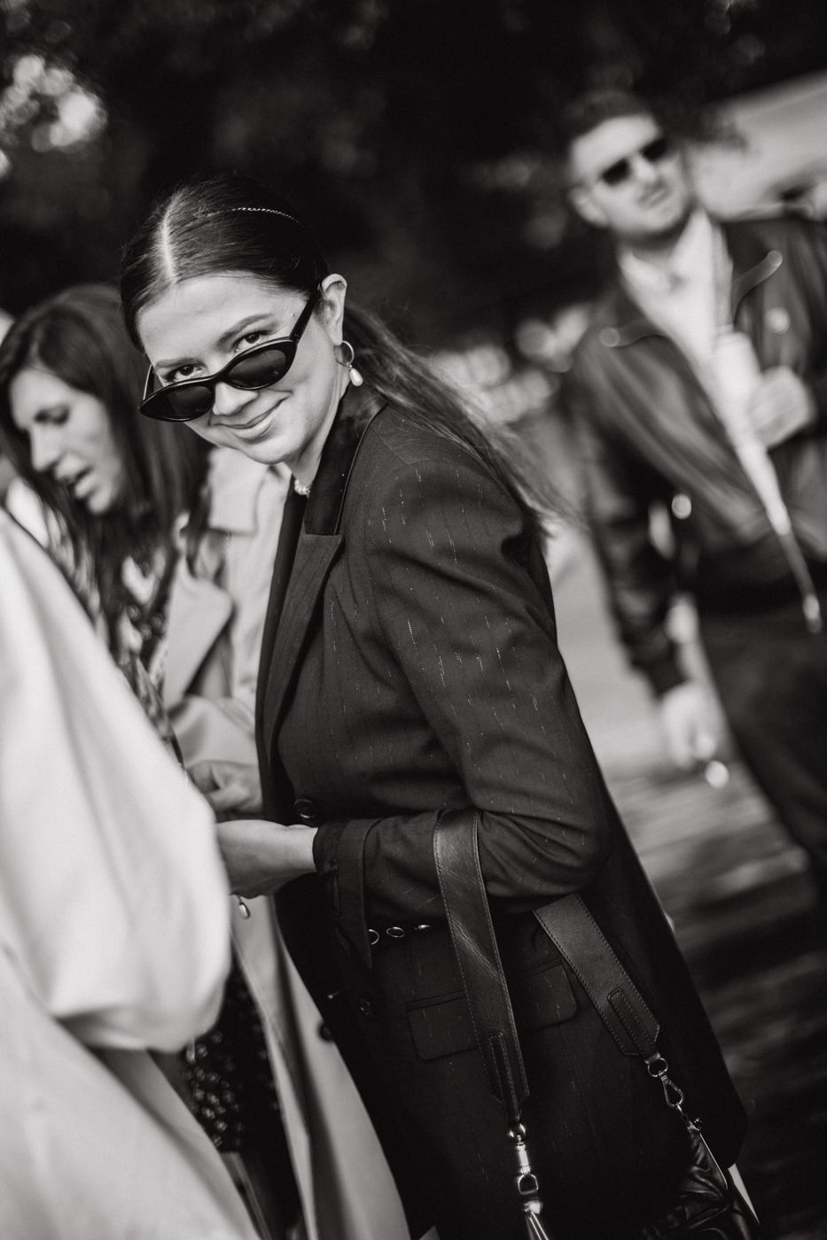 Black and white candid photos showing a person in dark clothing laughing and looking down in a natural, joyful moment.