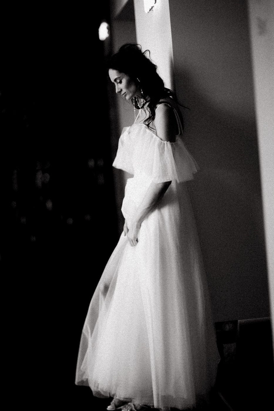 Black and white artistic portrait series showing a bride in a short tulle dress creating dramatic silhouettes.