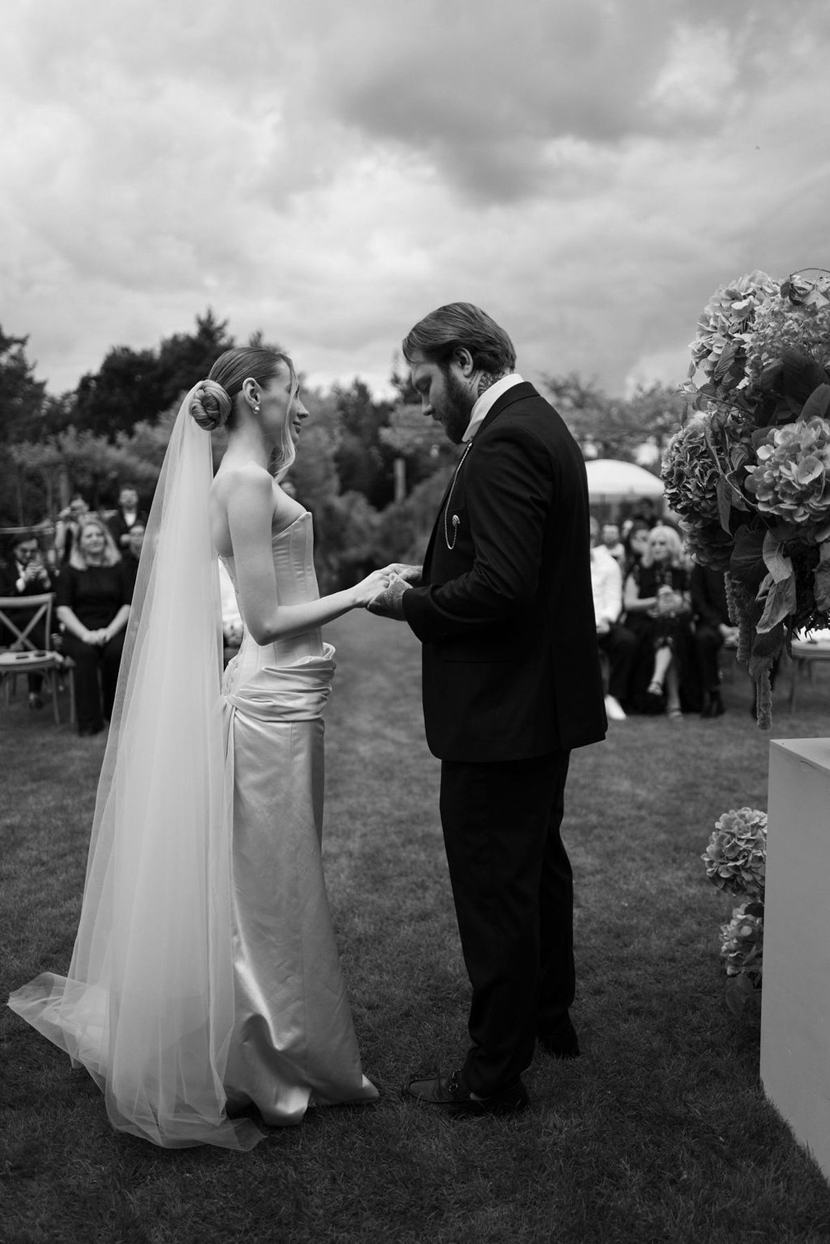 Black and white sequence of wedding photos showing couples dancing together on a grassy lawn during an outdoor reception.