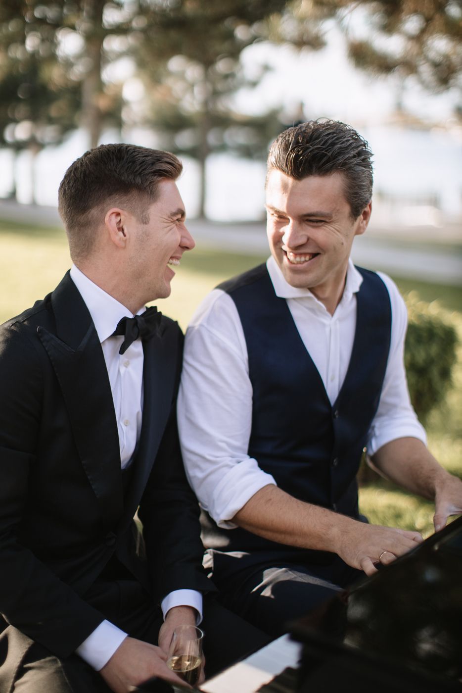 Two people sharing a candid laughing moment at an outdoor event.
