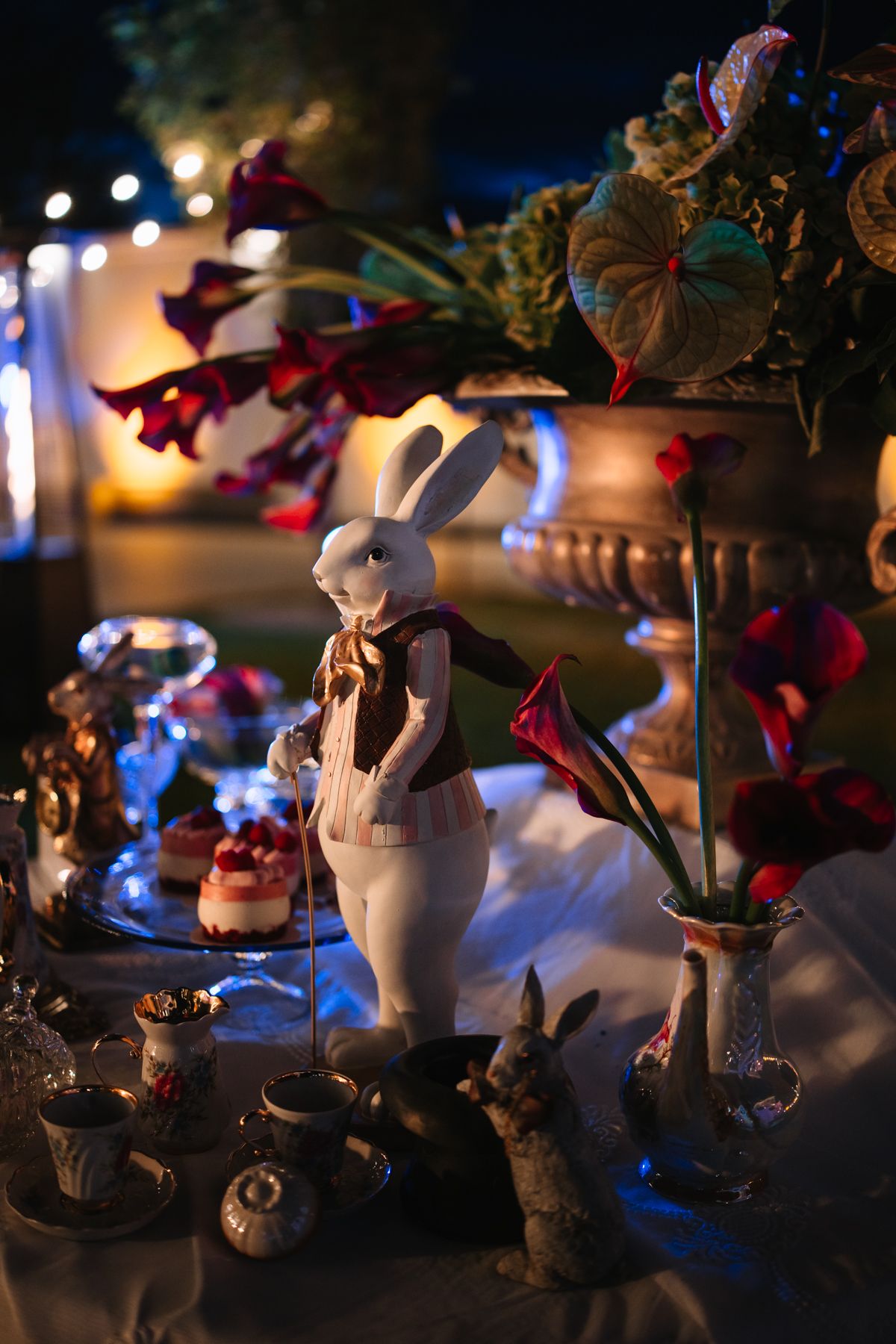 A whimsical display with a white rabbit figurine surrounded by decorative elements and soft bokeh lights in the background.